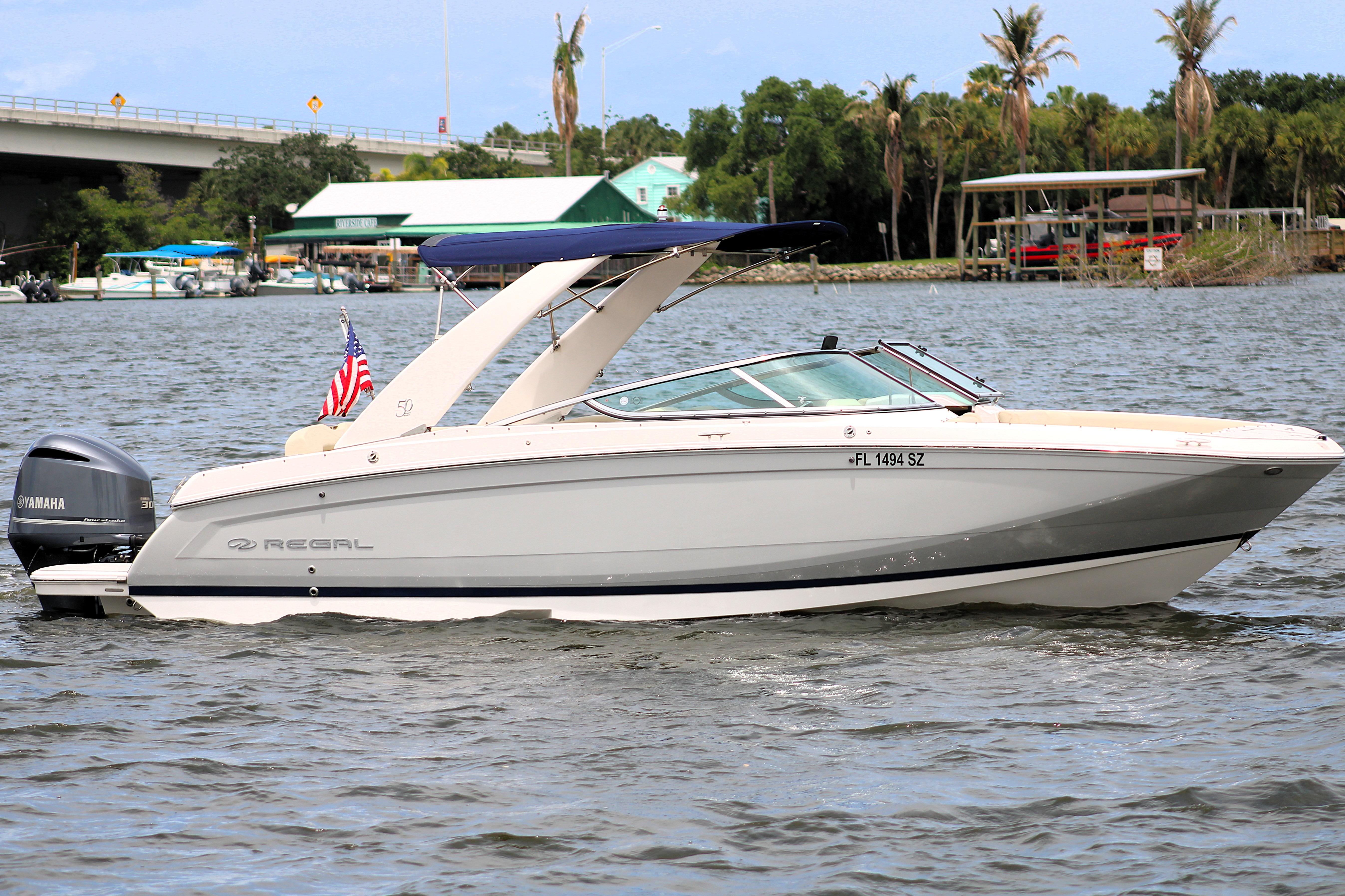 2021 Regal 26 OBX boat cruising on a river with a Yamaha outboard motor.