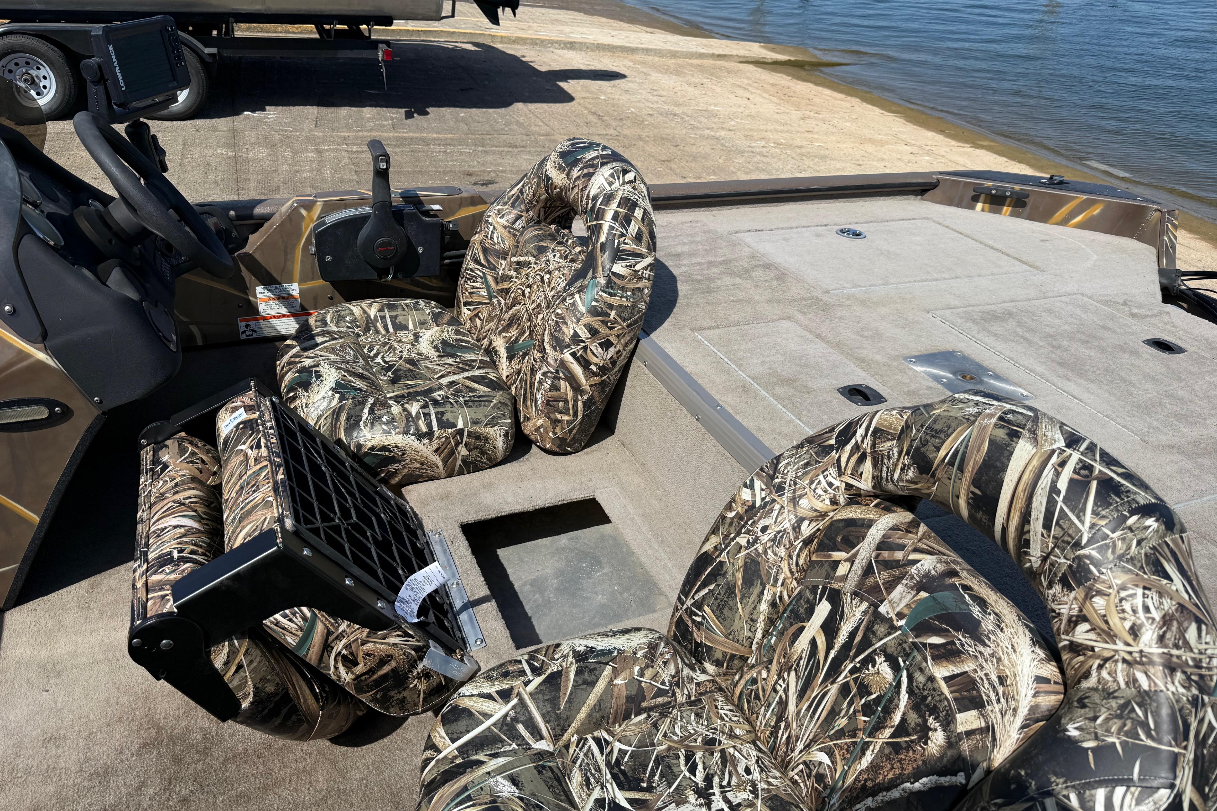 2010 SeaArk Stealth 190 boat with camouflage seats, docked by the water.