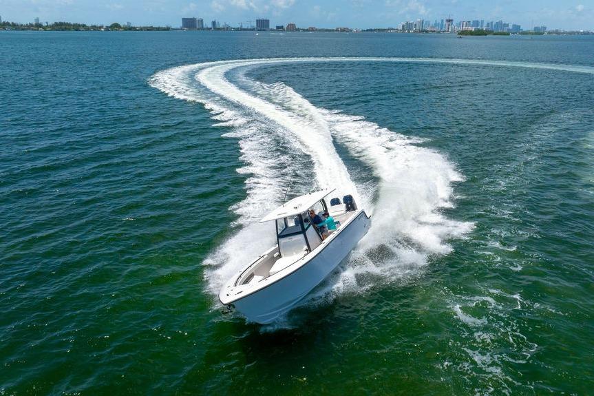 2027 Reef Runner 340 boat making a sharp turn on open water.