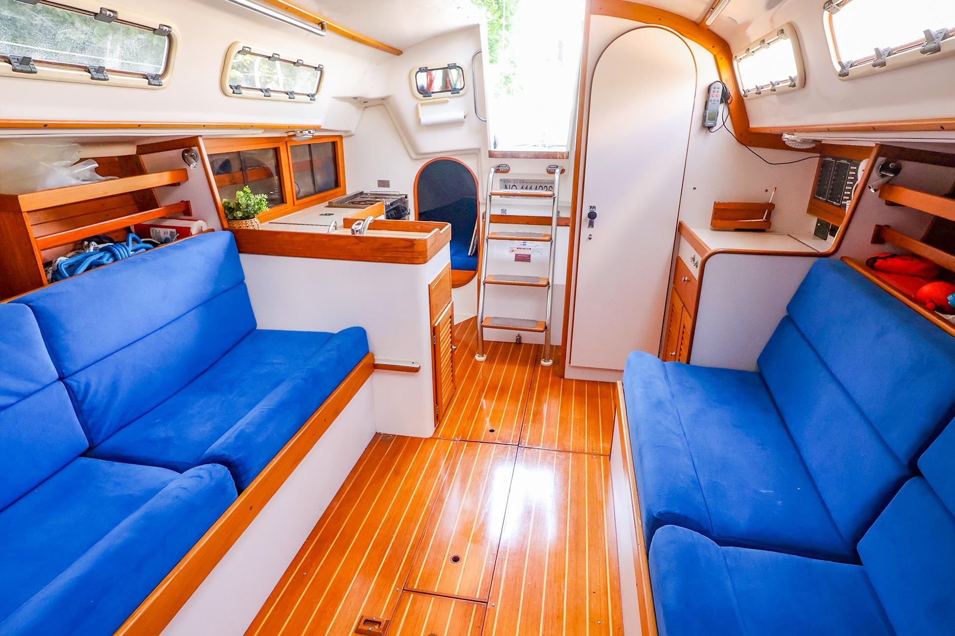 Interior of 2001 J Boats J/32 sailboat with blue seating and wooden flooring.