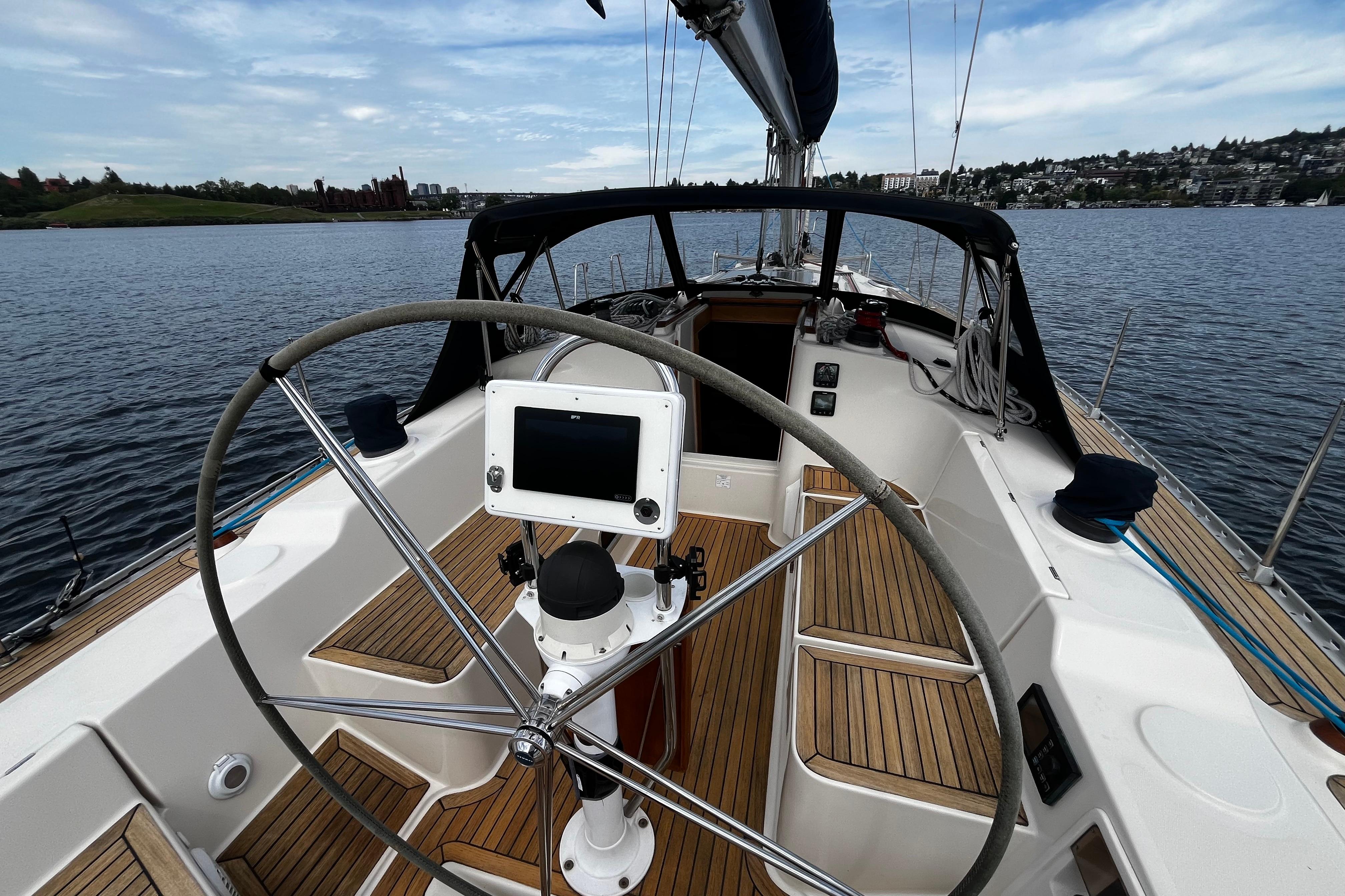 2004 Hanse 411 sailboat cockpit with steering wheel and navigation system on calm water.