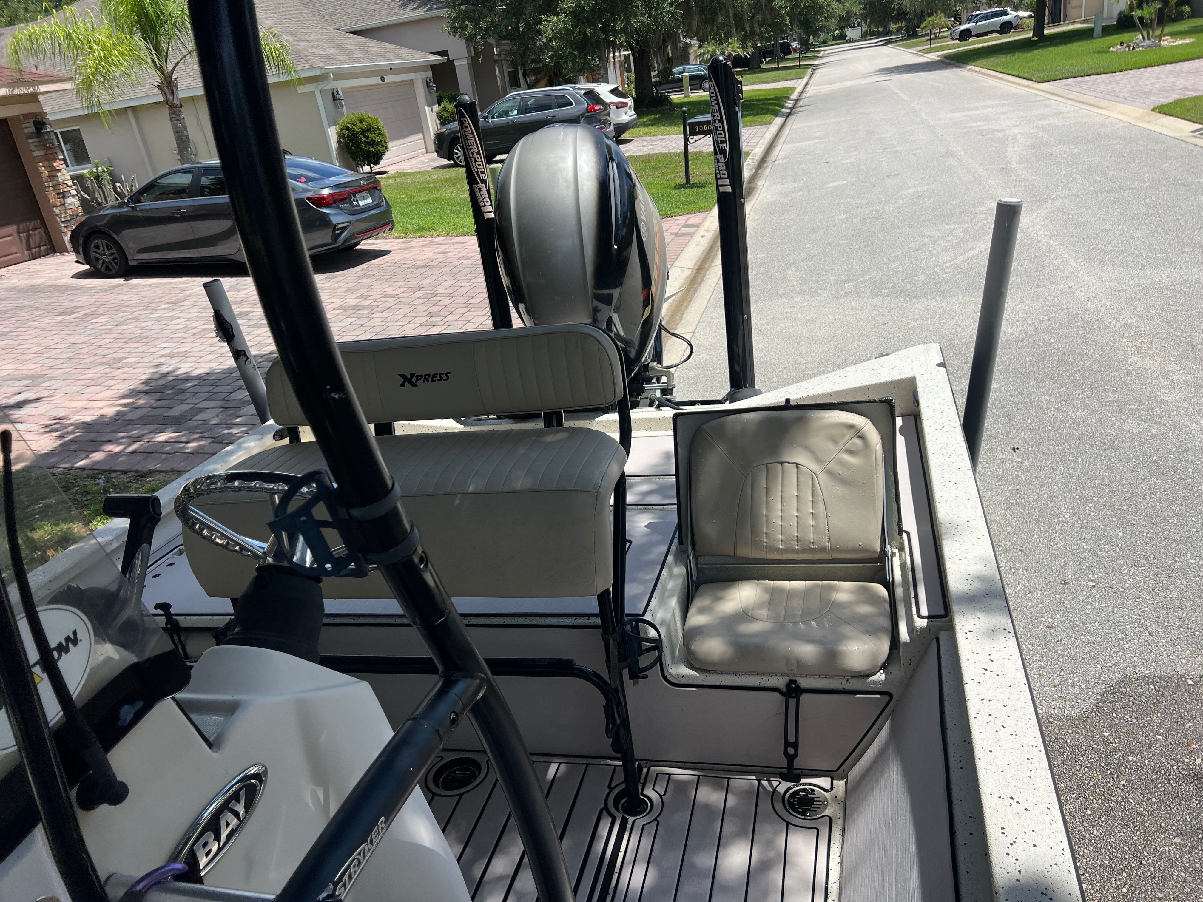 2016 Xpress H24B Bay boat parked on a residential street.