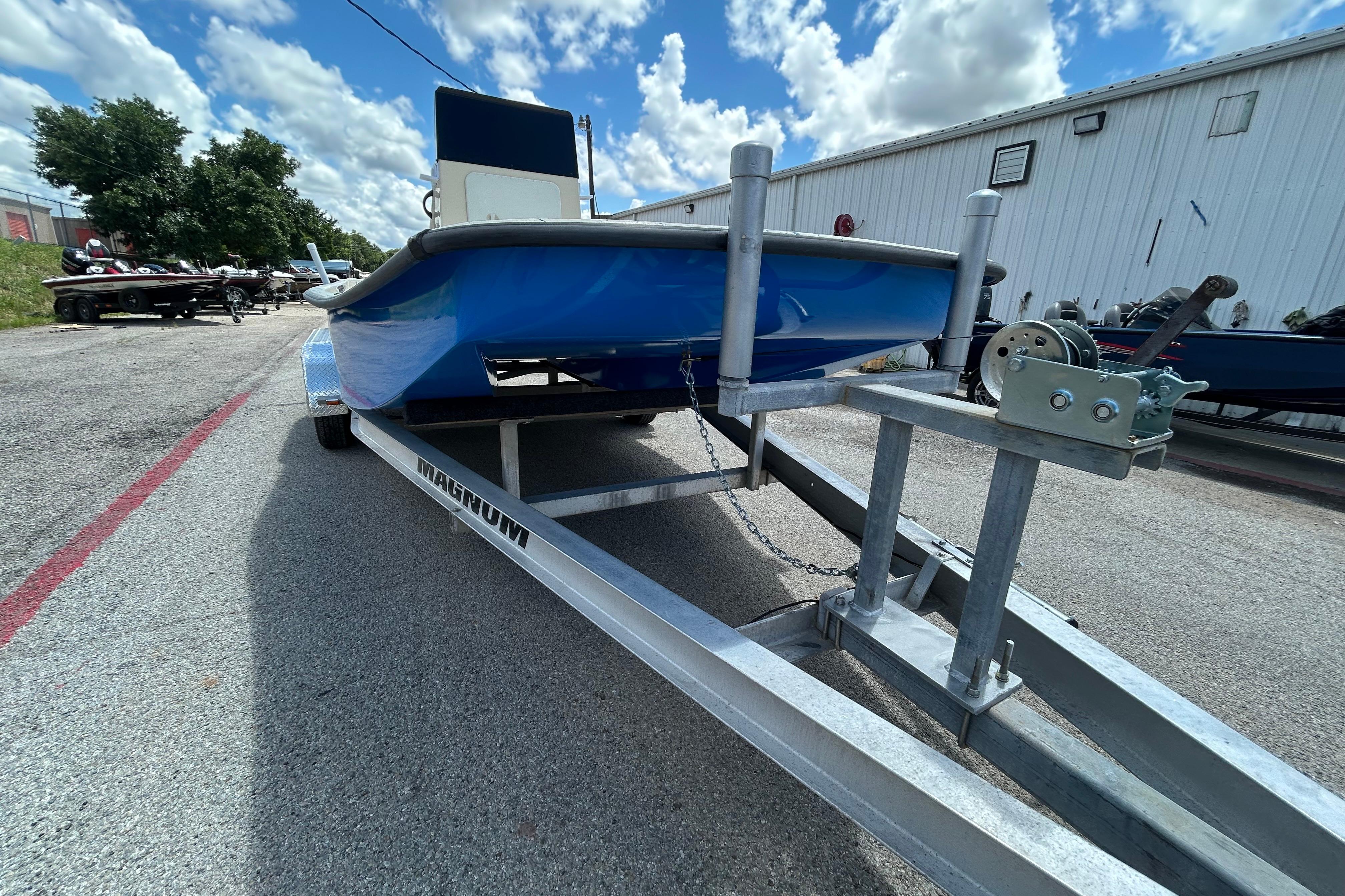 2007 Flats Cat 19 boat on trailer under a cloudy sky.