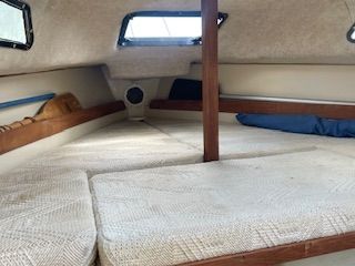 Interior of a 1986 Wellcraft Starwind 19 with sleeping area and windows.