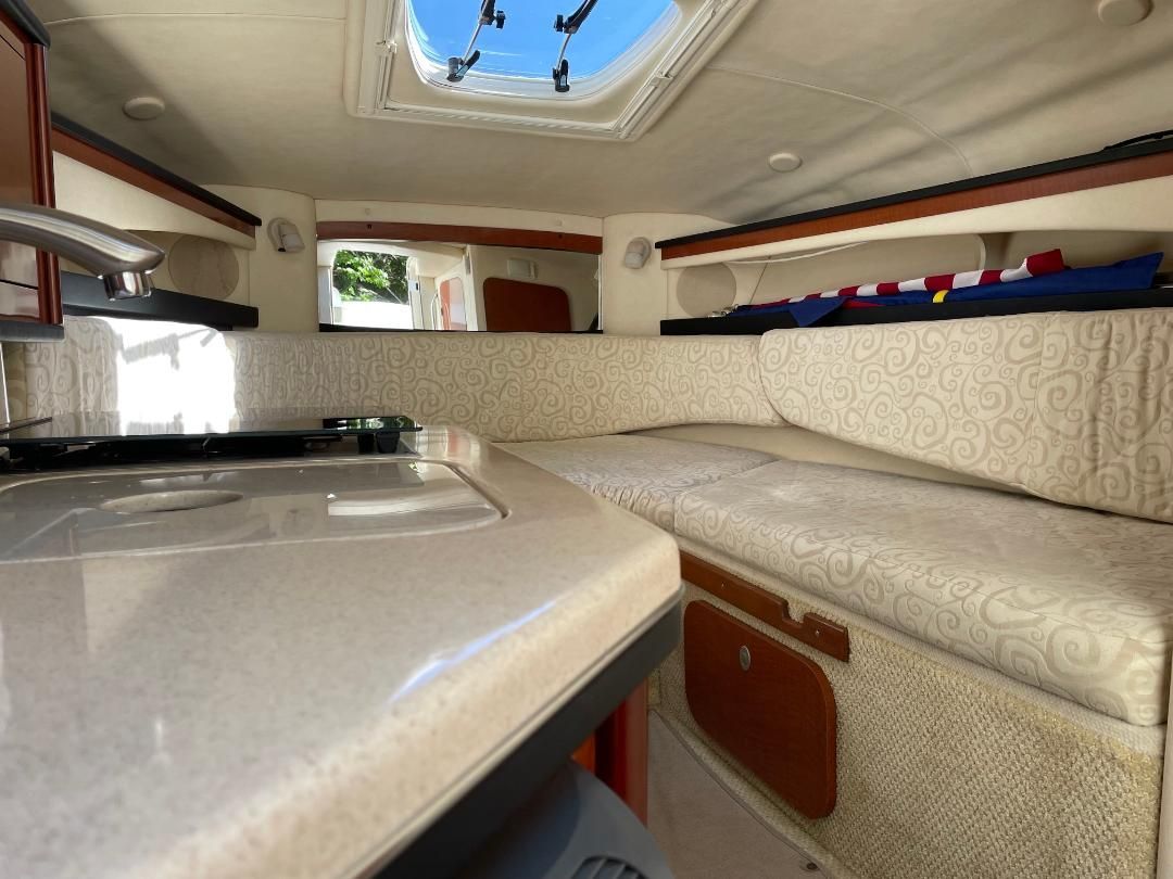 Interior of a 2005 Sea Ray Sundancer 260 with a kitchenette and seating area.