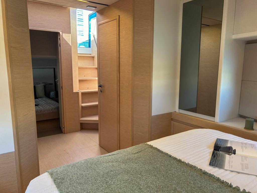 Interior cabin of 2024 Solaris Power 52 Open yacht with wooden finishes and cozy bedding.