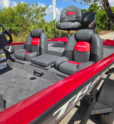 2025 Tracker Pro Team 175 boat with red and gray seating, outdoors.