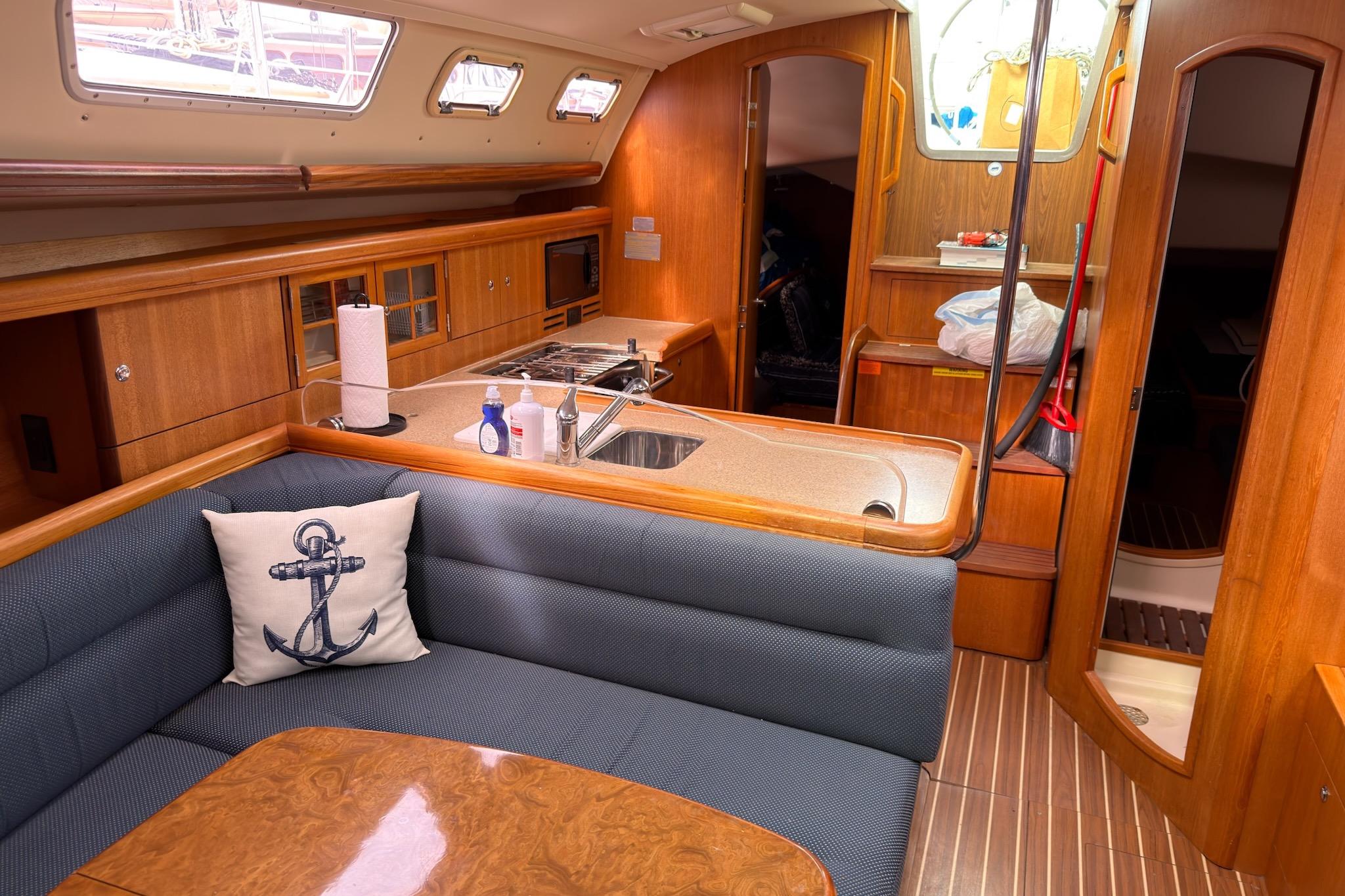 Interior of a 2007 Hunter 38 sailboat with cozy seating and wooden cabinetry.