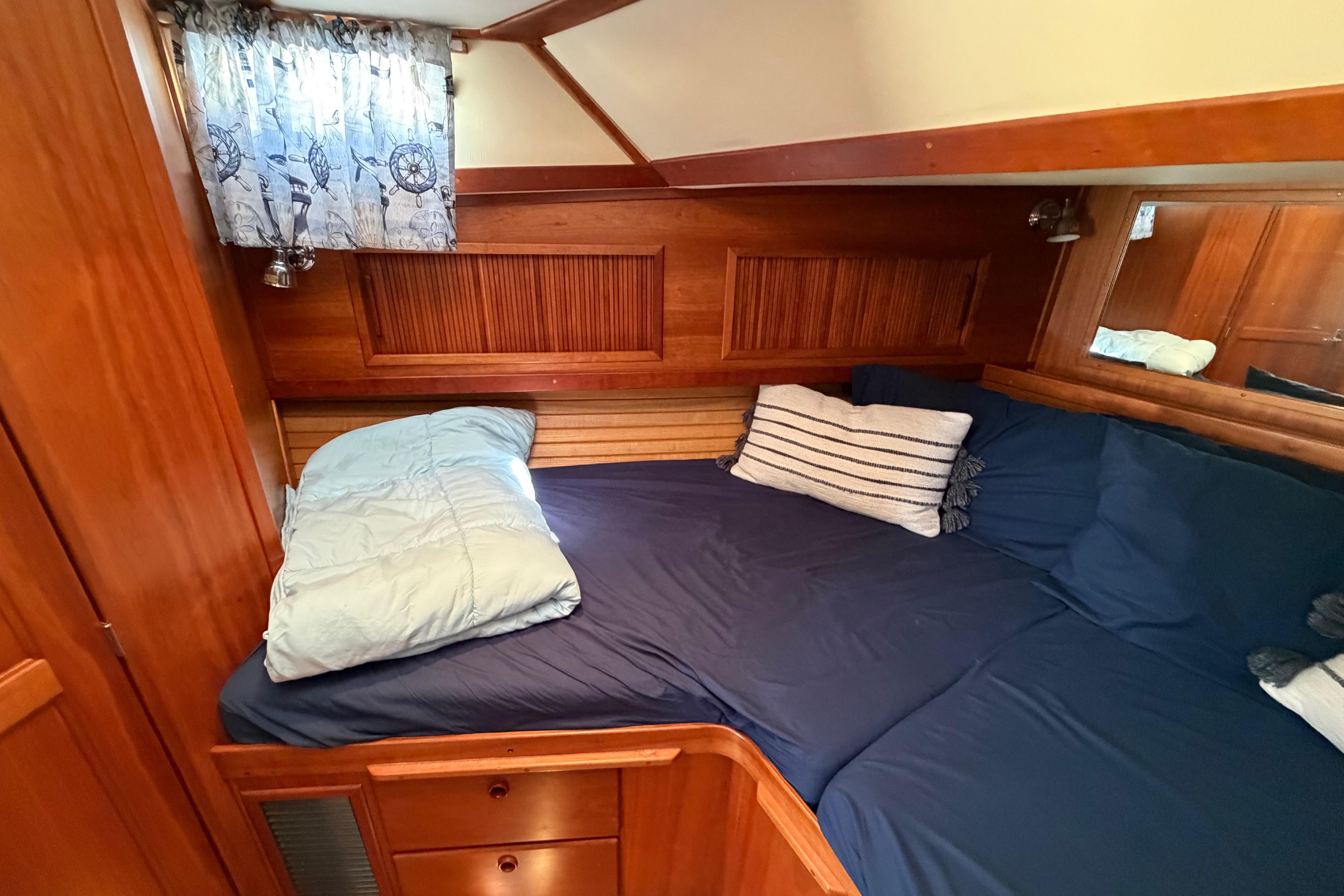 Cozy cabin interior of 2000 Sabreline 36 Express with wooden accents and nautical-themed decor.