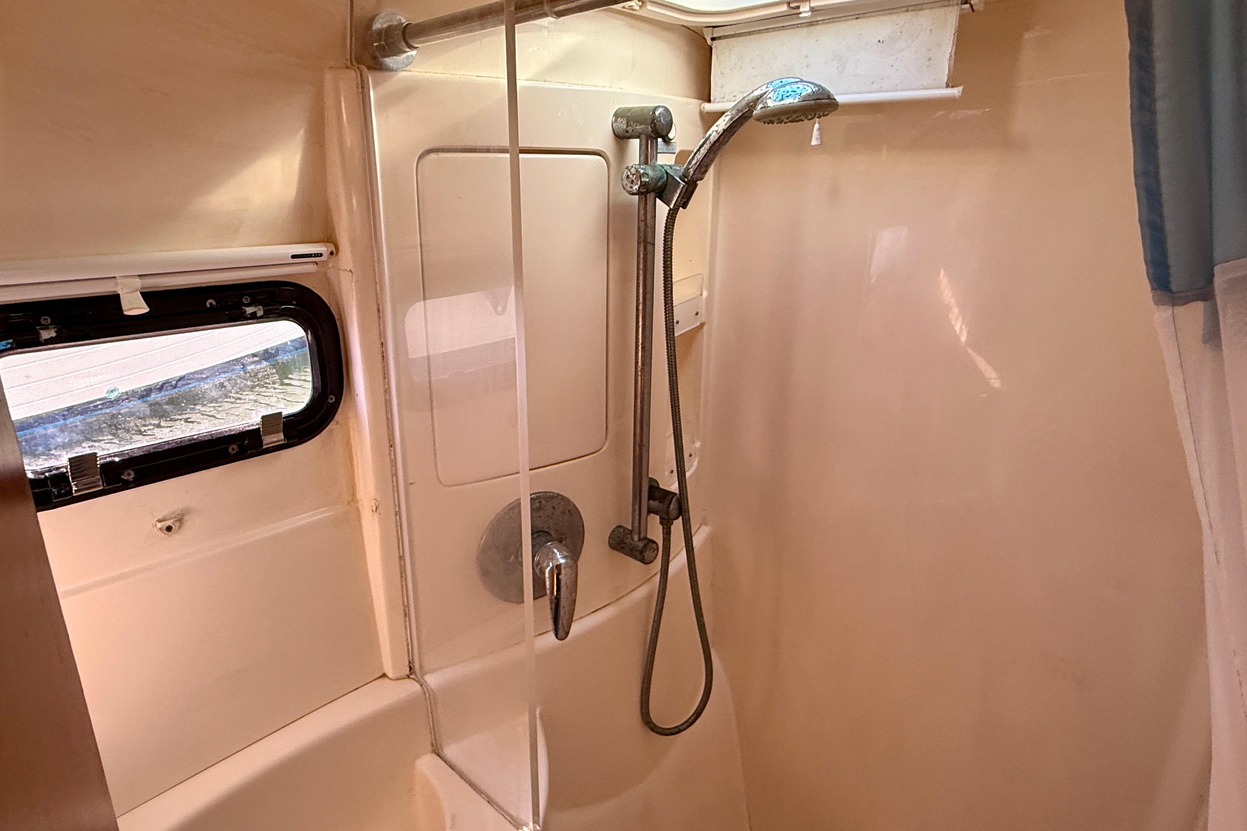 Shower area in a 2010 Leopard 38 yacht, featuring a handheld showerhead and window.