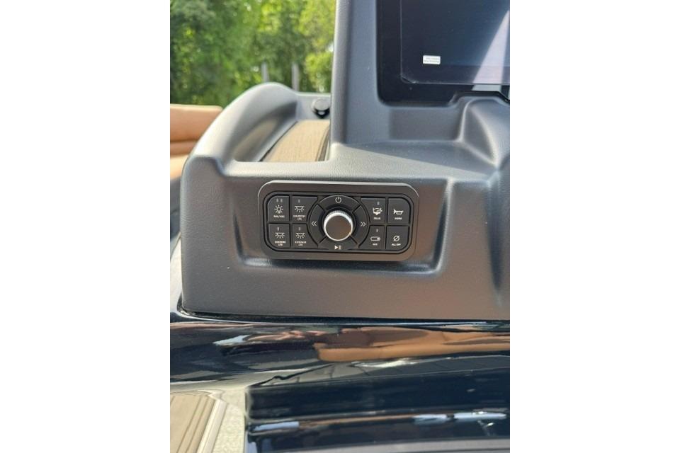 Control panel of 2026 Regency 230 DL boat, featuring various buttons and a central dial.