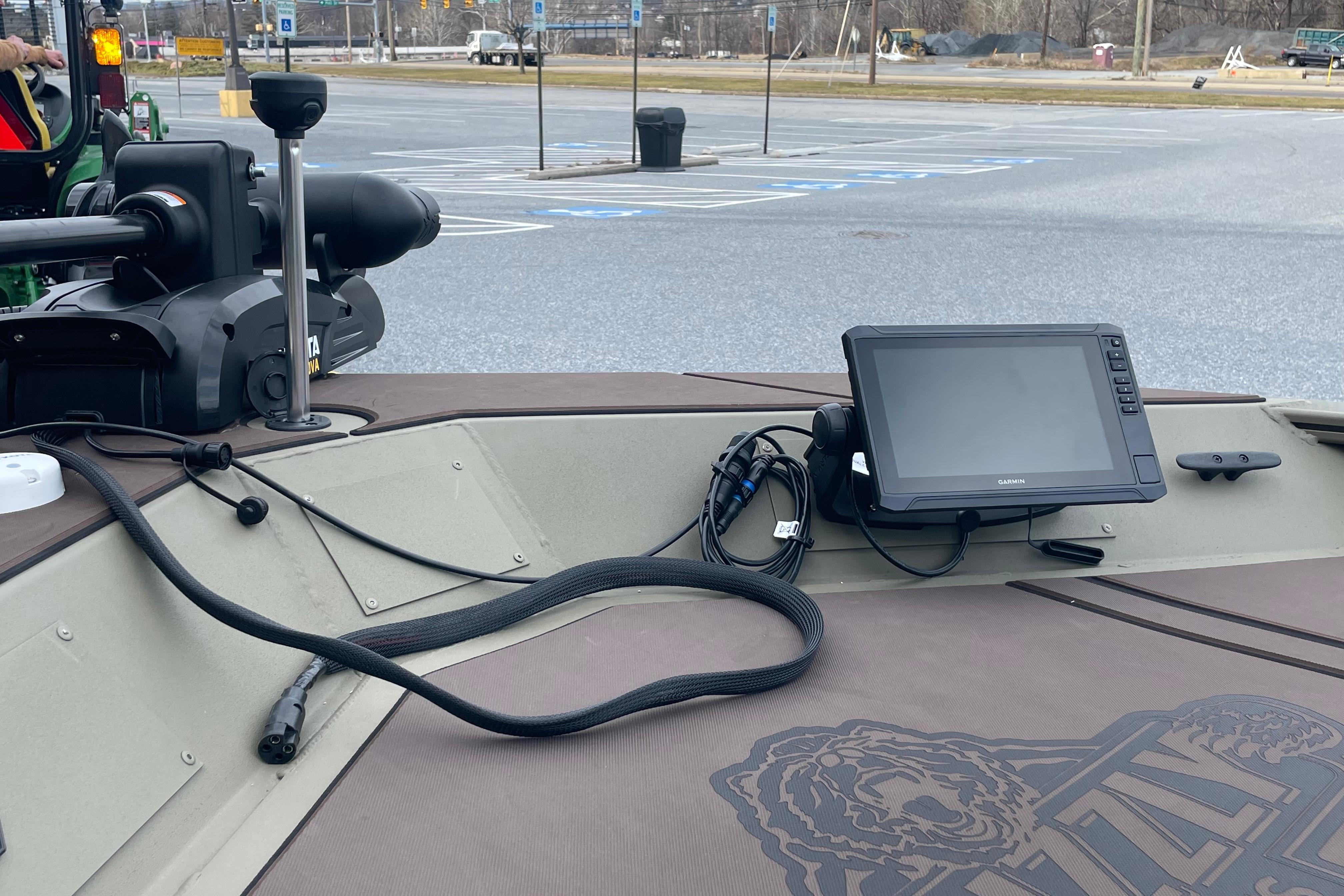 2026 Tracker Grizzly 1860 CC boat with Garmin navigation system in parking lot.