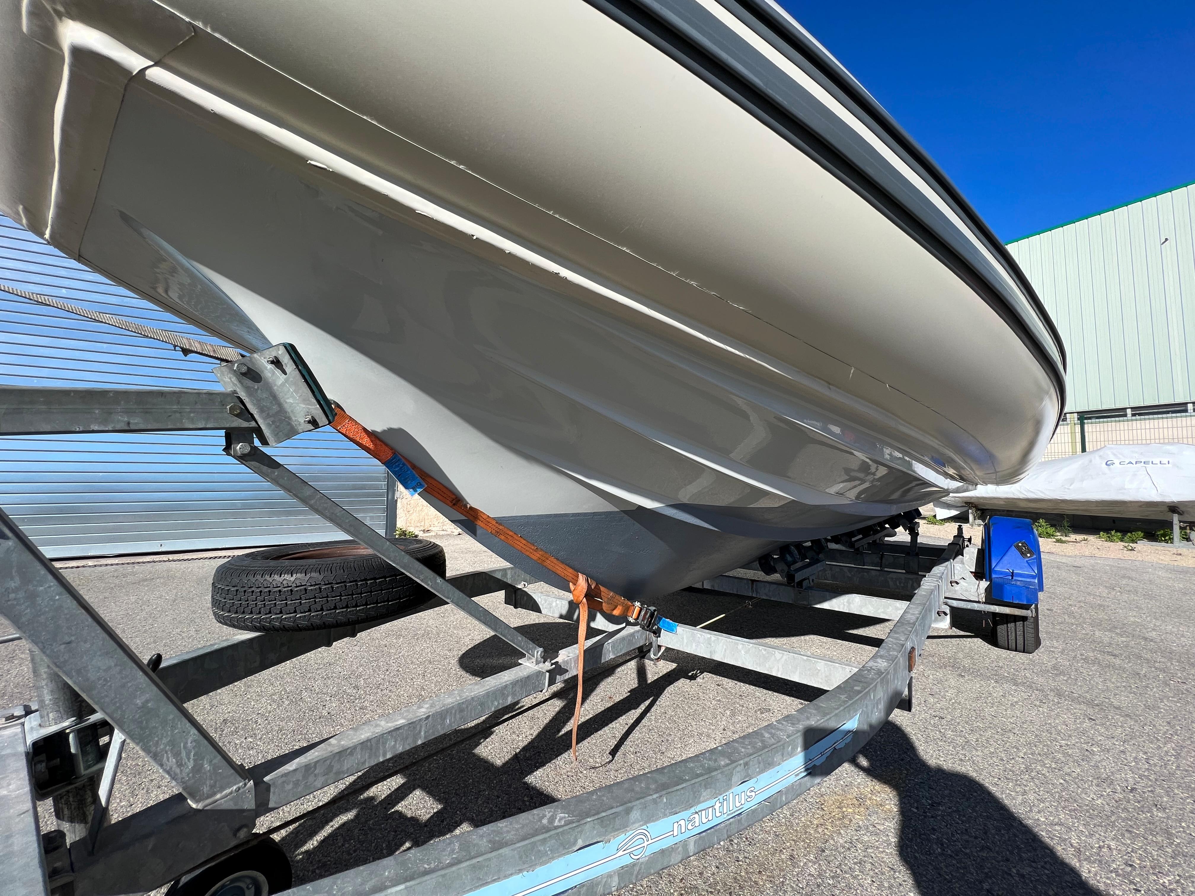 2020 Capelli TEMPEST 650 BR boat on trailer, side view under clear blue sky.