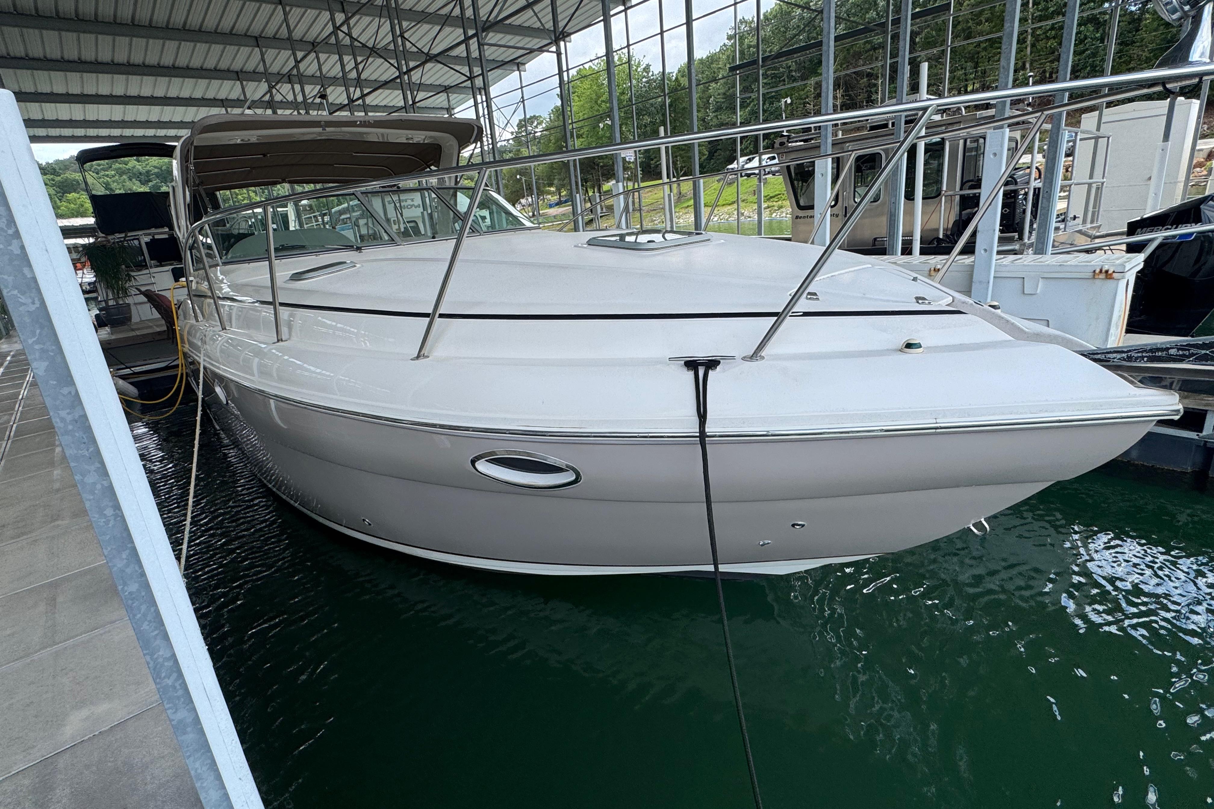 2004 Rinker Fiesta Vee 312 boat docked in a covered marina.