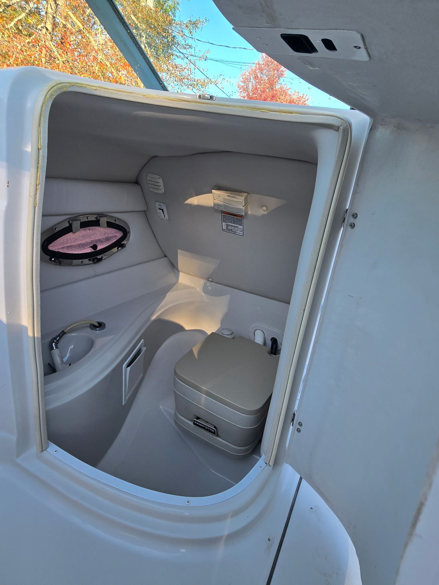 Interior of a 2005 Crownline 240 EX with a toilet and porthole.