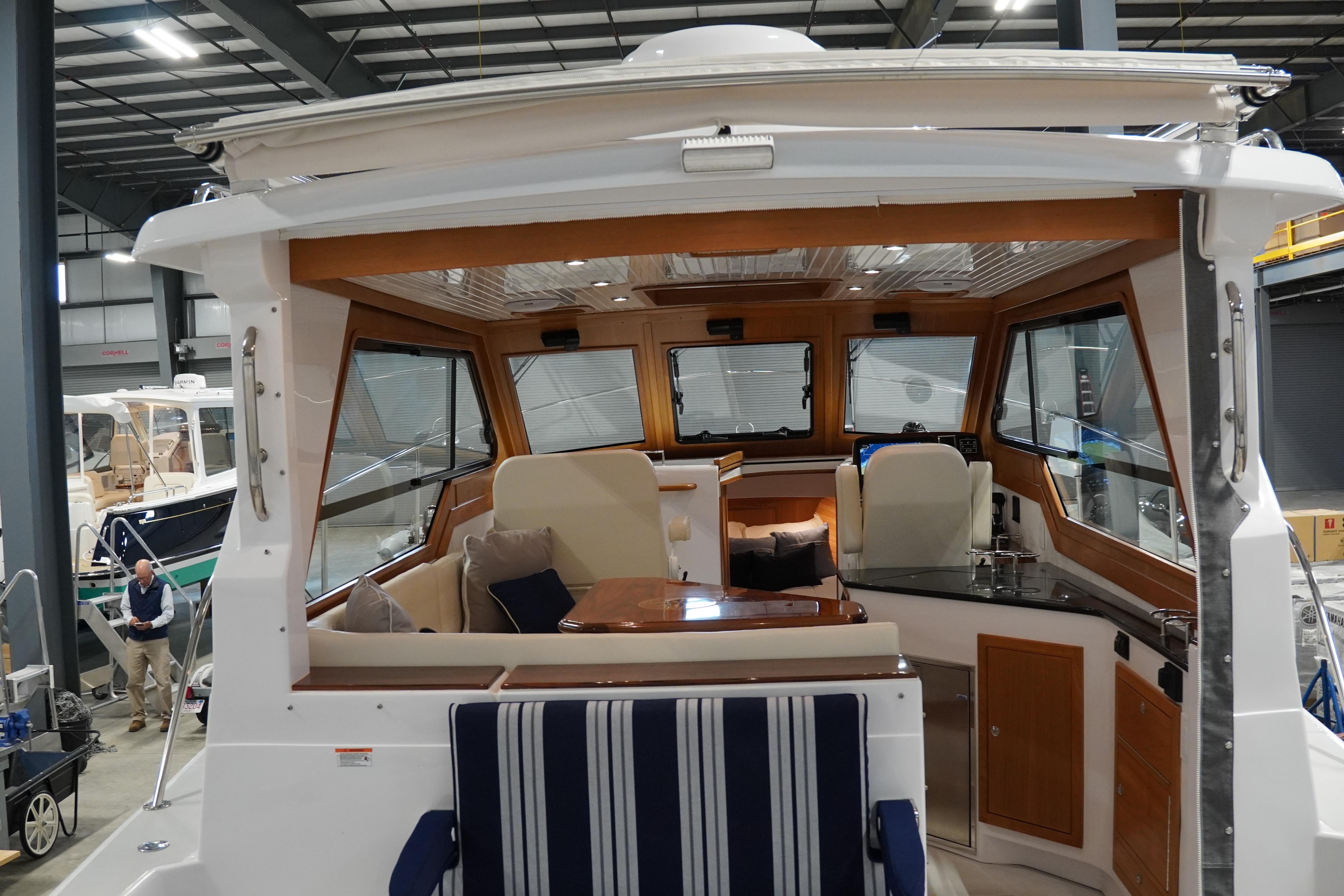 2024 True North 34 boat interior with seating, table, and helm in a showroom.