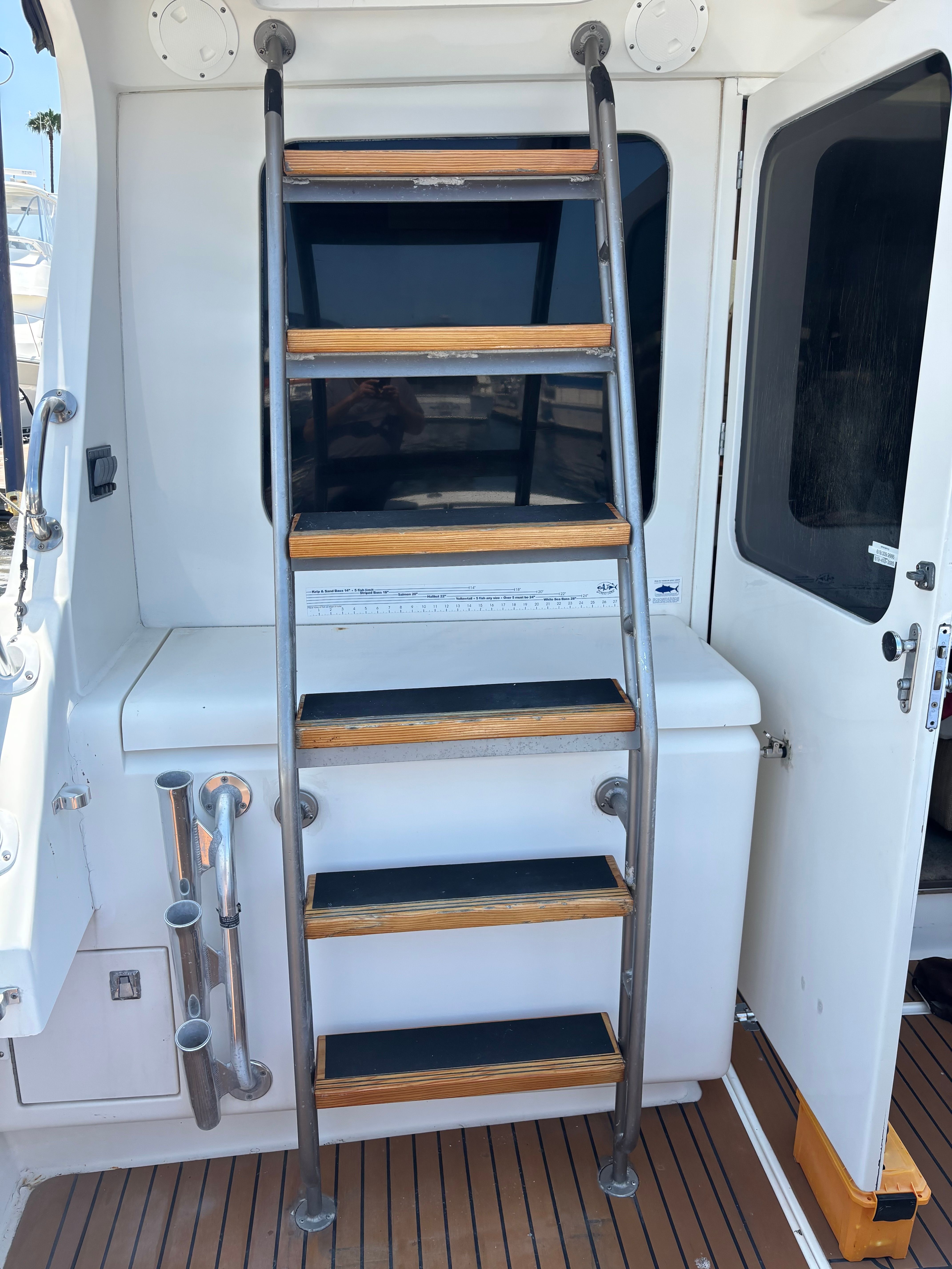 Staircase on a 1989 Luhrs 350 Tournament boat, featuring wooden steps and metal railing.