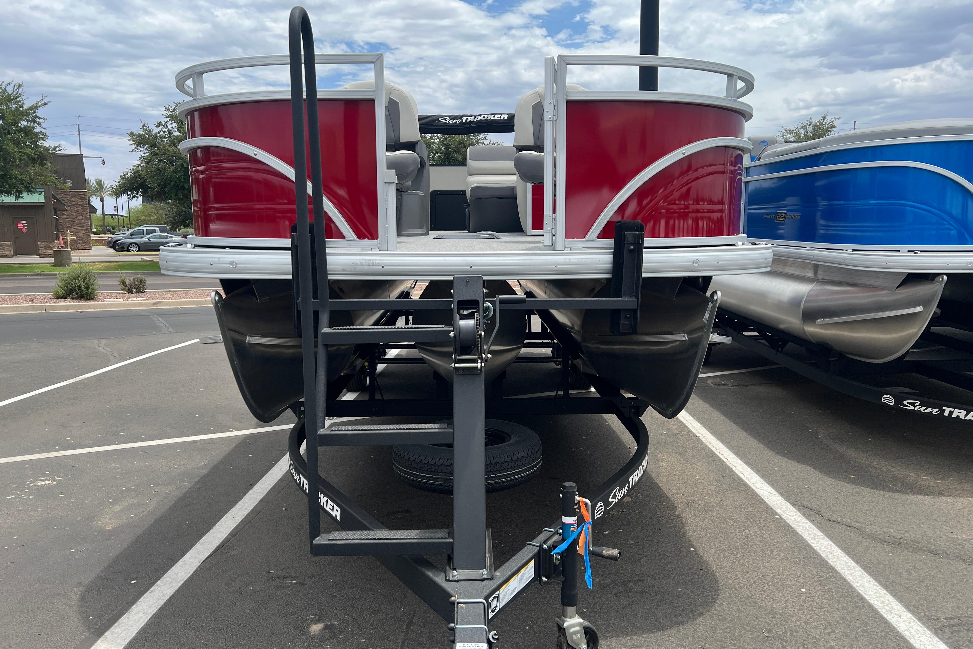 2026 Sun Tracker Fishin' Barge 22 XP3 pontoon boat on trailer, red exterior.