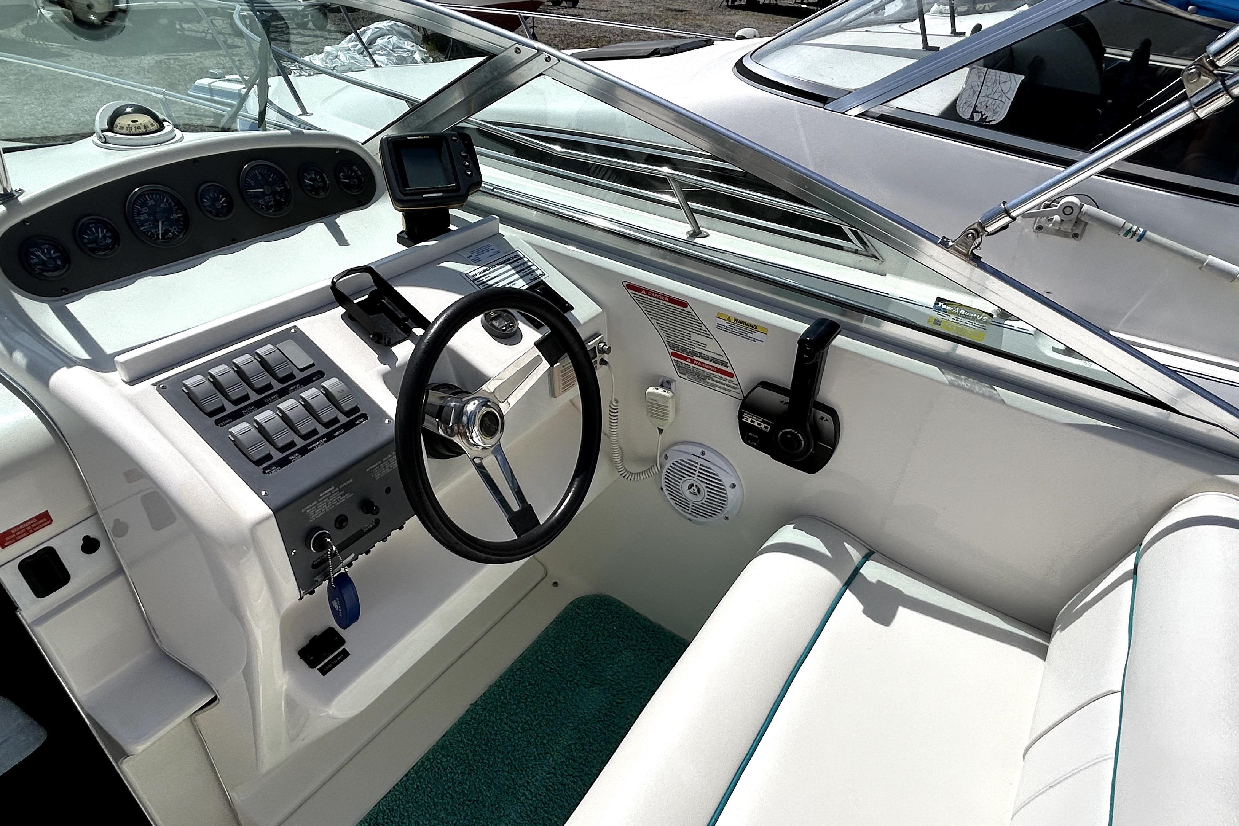 1995 Sea Ray 250 Sundancer boat cockpit with steering wheel and control panel.