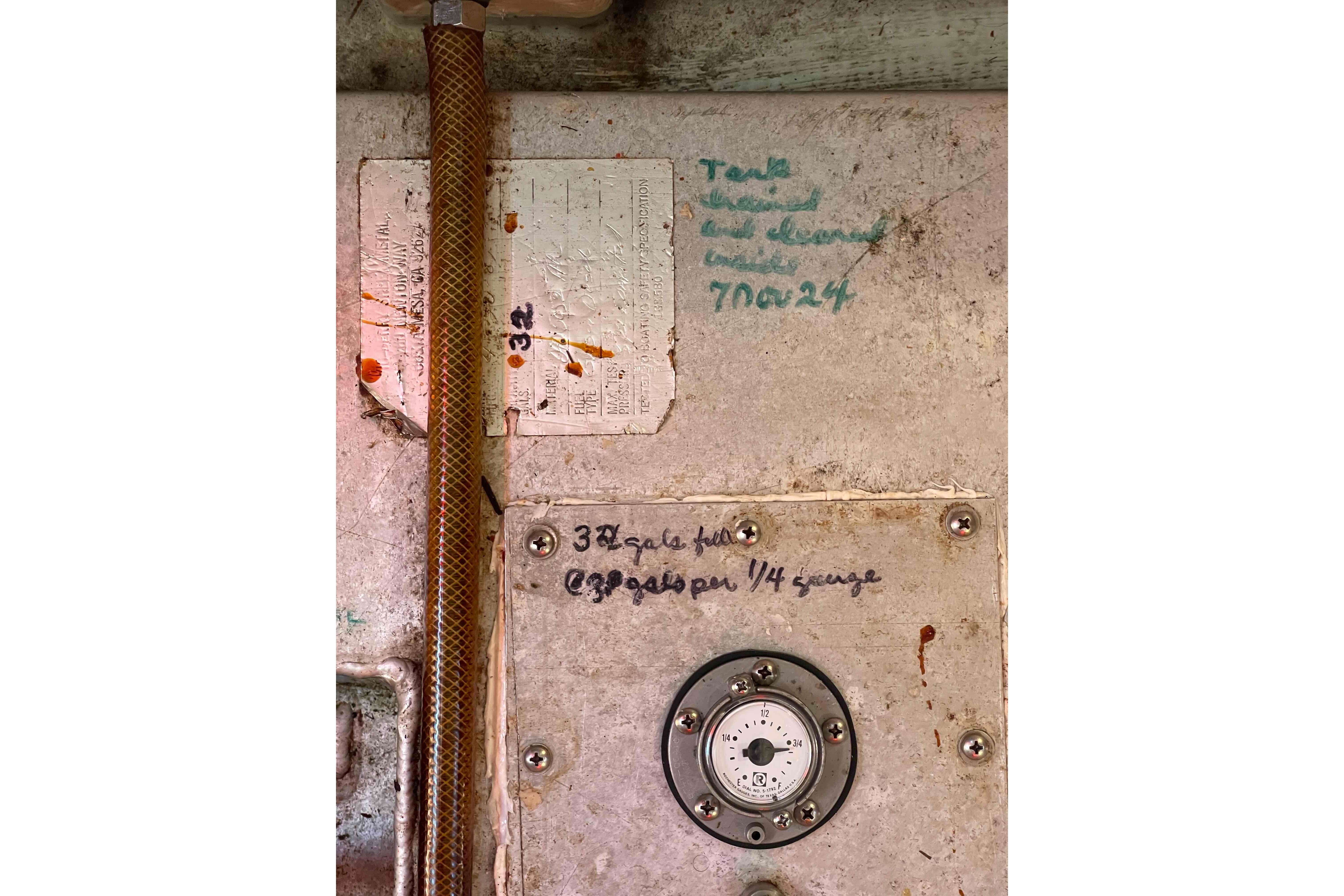 Engine compartment of a 1987 Pacific Seacraft 34 sailboat with handwritten maintenance notes.