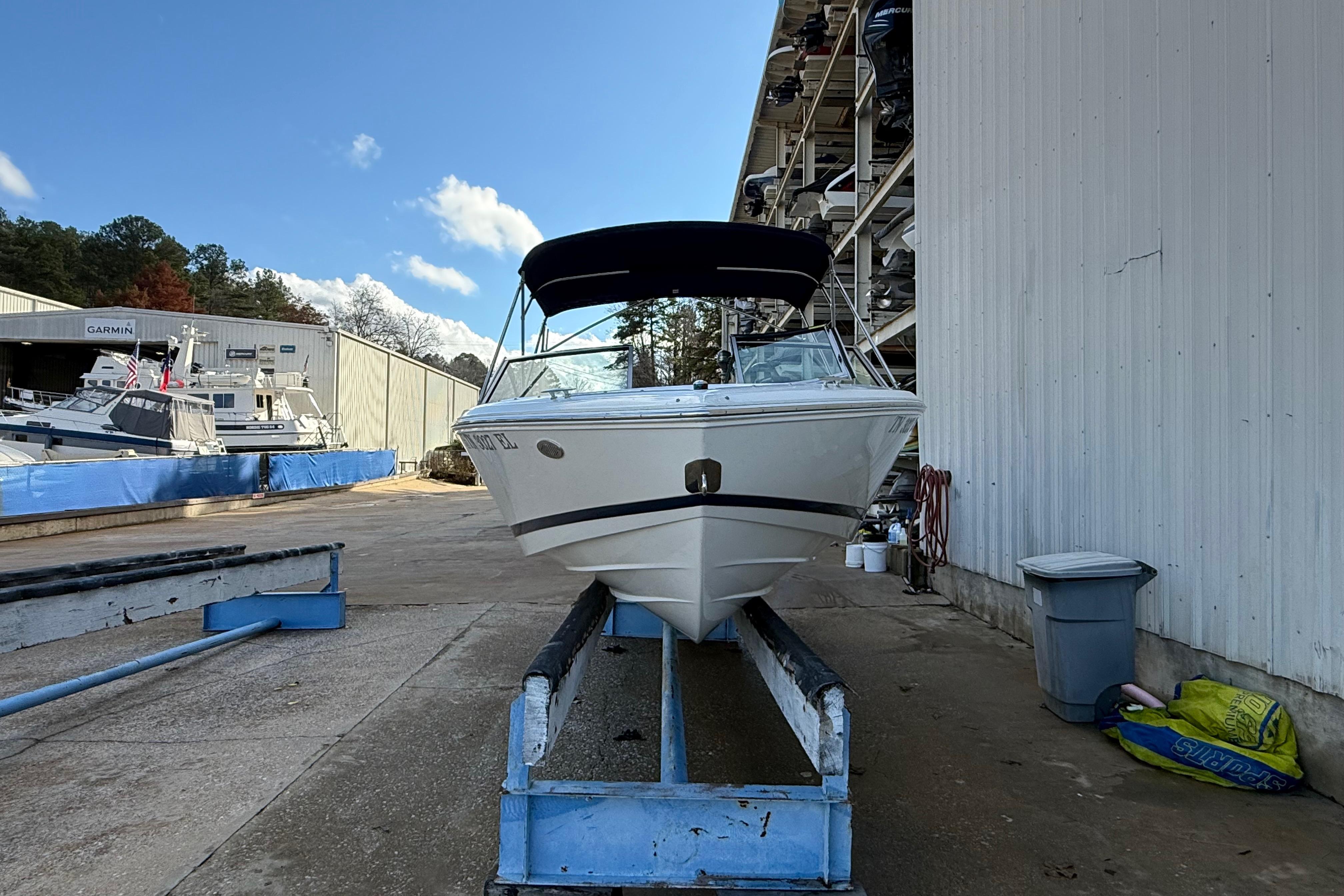 2015 Cobalt 200 boat in storage, marina background, clear sky.