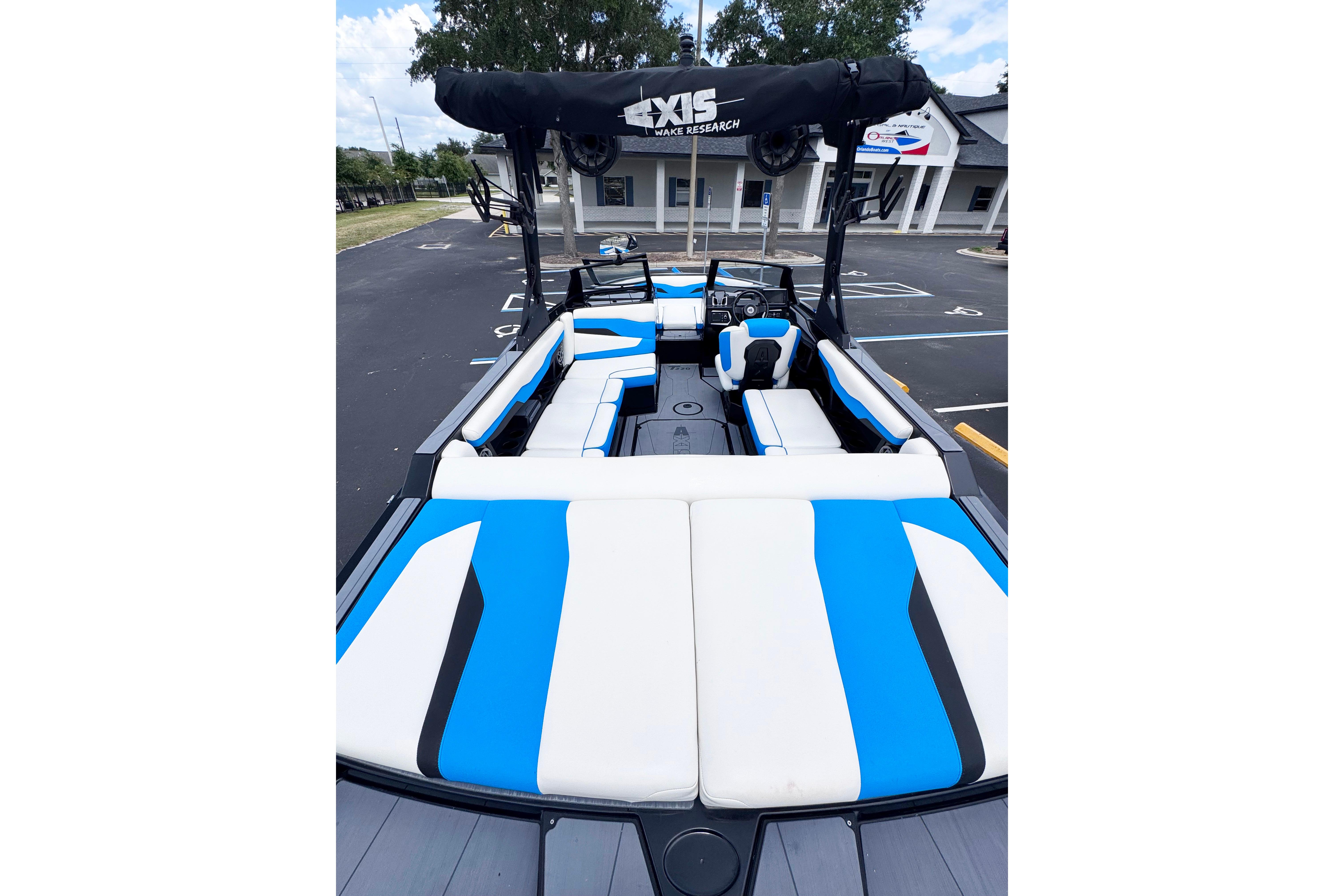 2022 Axis T220 boat with blue and white seating, parked outdoors.