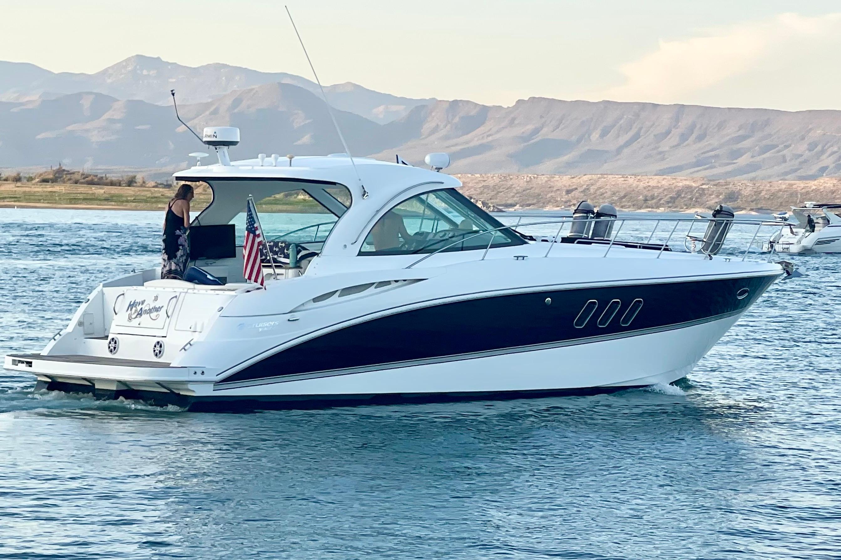 2011 Cruisers Yachts 390 Sports Coupe on water with mountainous backdrop.
