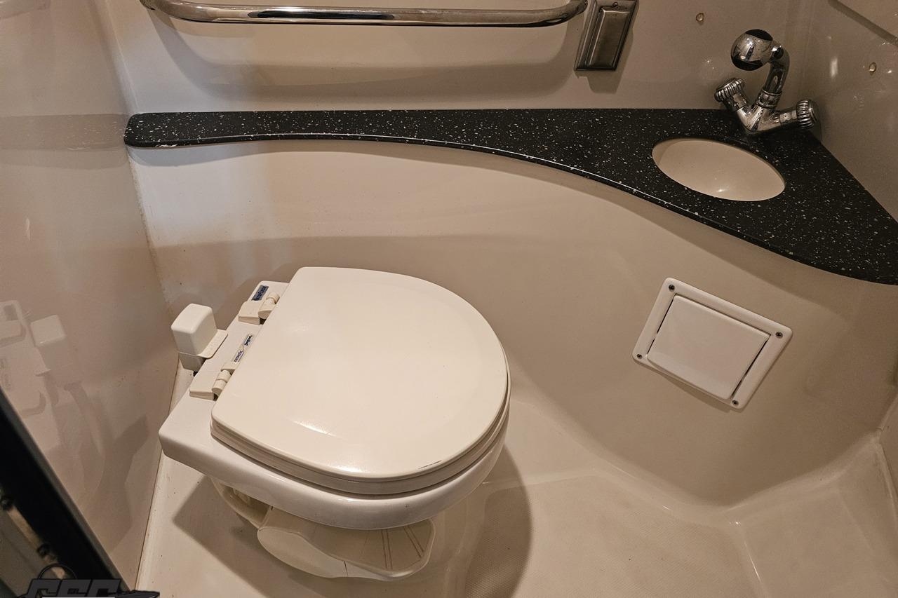Compact bathroom in a 2008 Baja 335 Performance boat with toilet and sink.