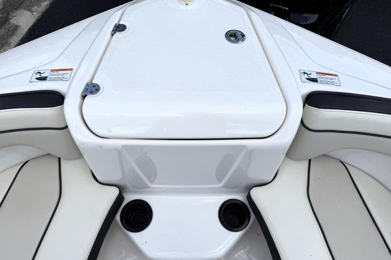 2017 Yamaha Boats SX210 bow seating area with storage compartment and cup holders.