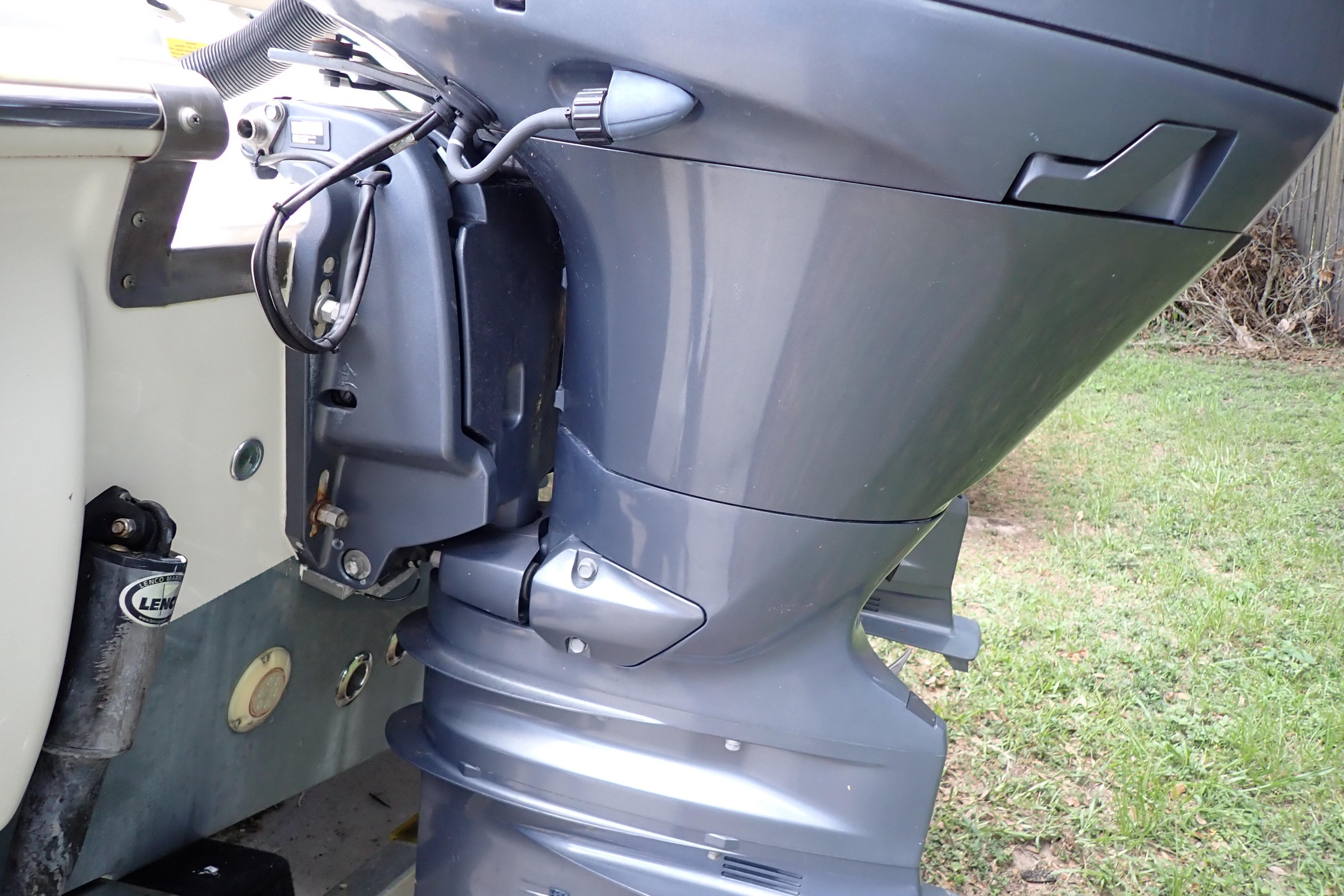 Close-up of a 2019 Key West 263 FS boat motor on grass.