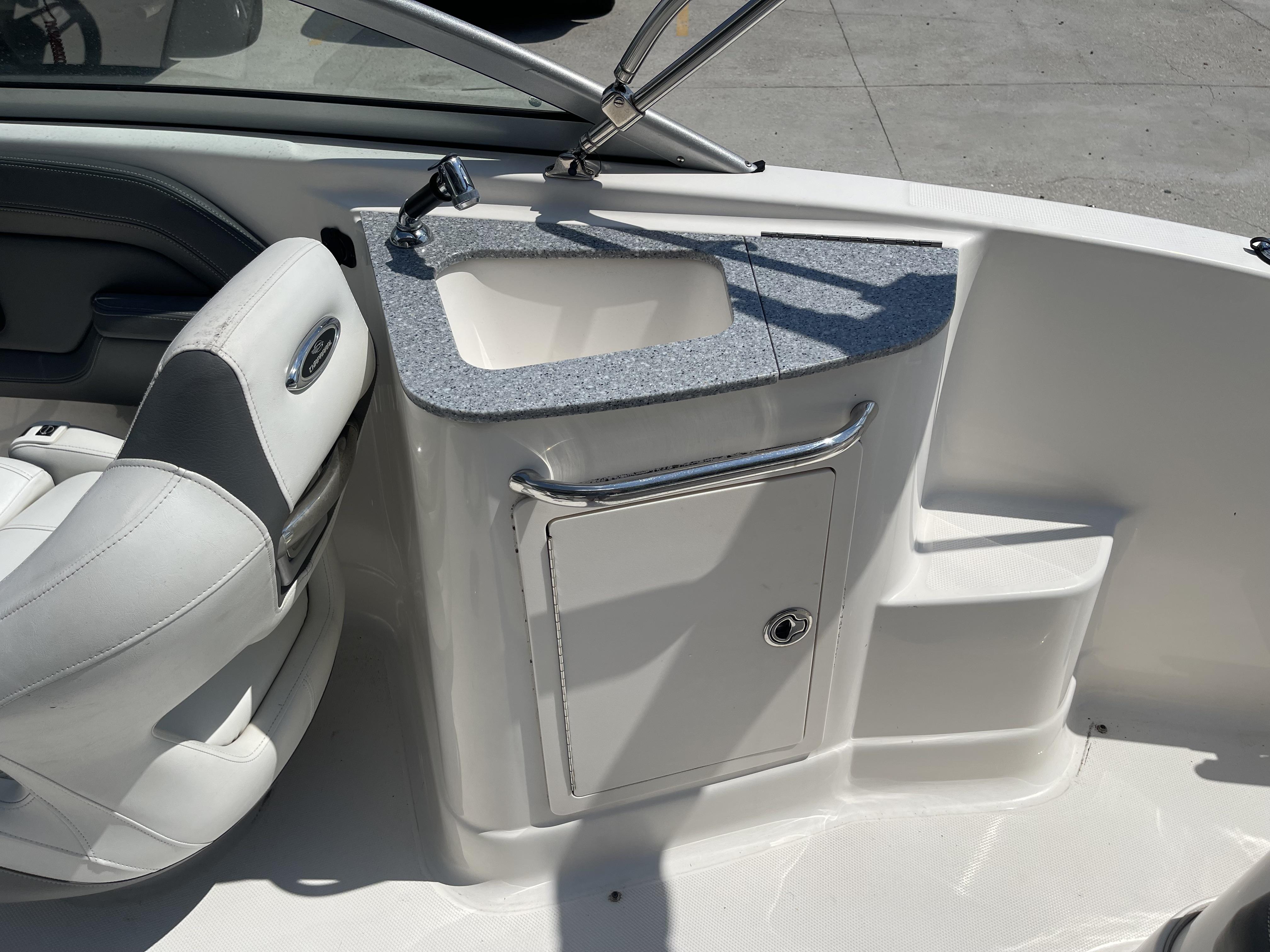 2014 Chaparral Sunesta 224 boat interior with sink and seating area.