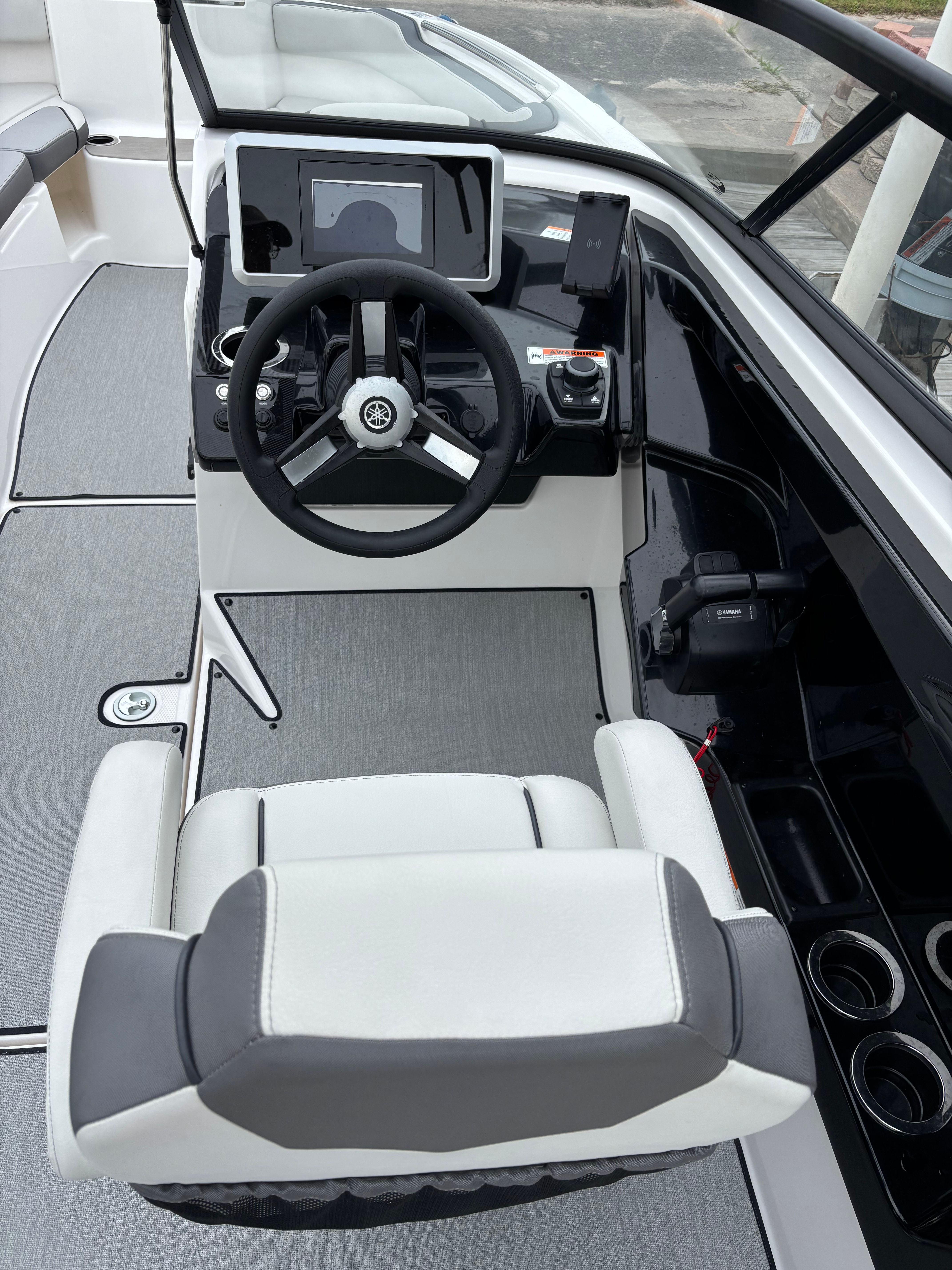 The cockpit of a Yamaha AR250 boat with steering wheel and dashboard.