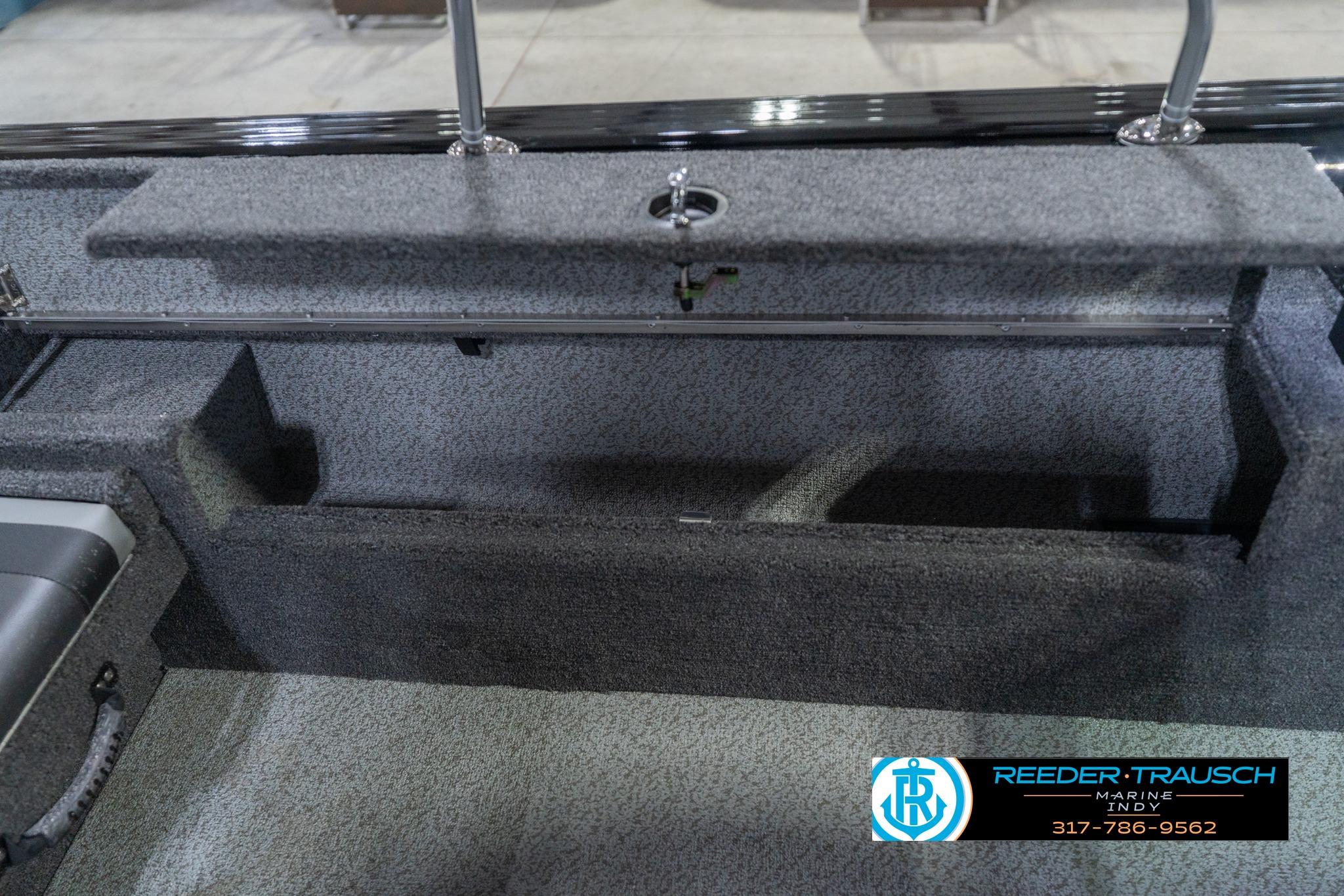 2026 Lund 2075 Impact XS boat interior storage compartment, featuring durable gray carpeting.