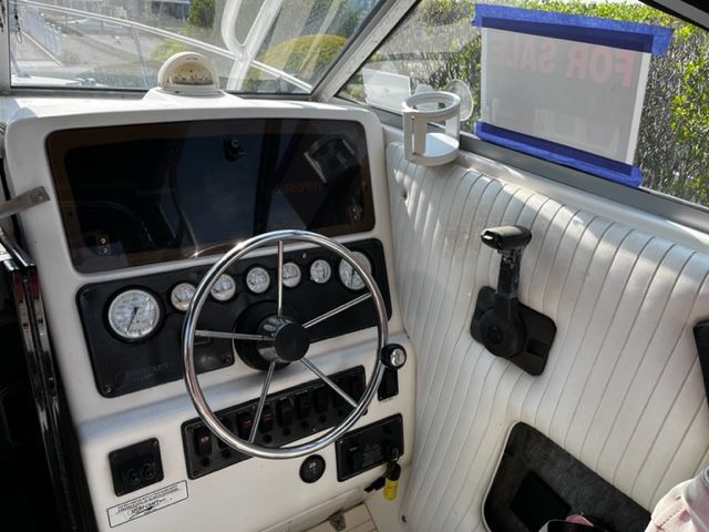 The image shows the helm of a 1998 Sport-Craft 252 Sport Fish boat with instruments and steering wheel.