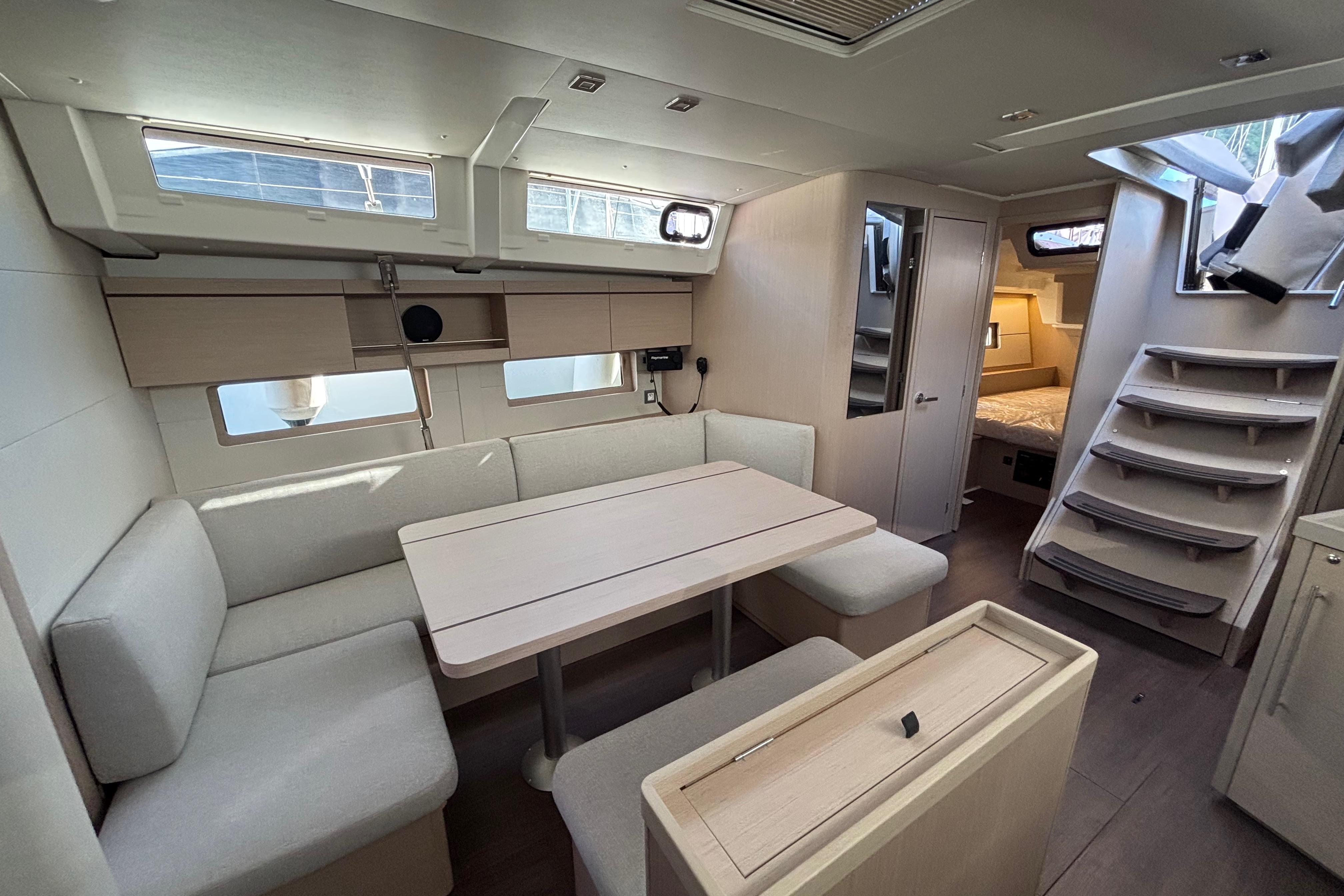 Modern interior of 2023 Beneteau Oceanis 46.1 yacht with dining area and cabin.