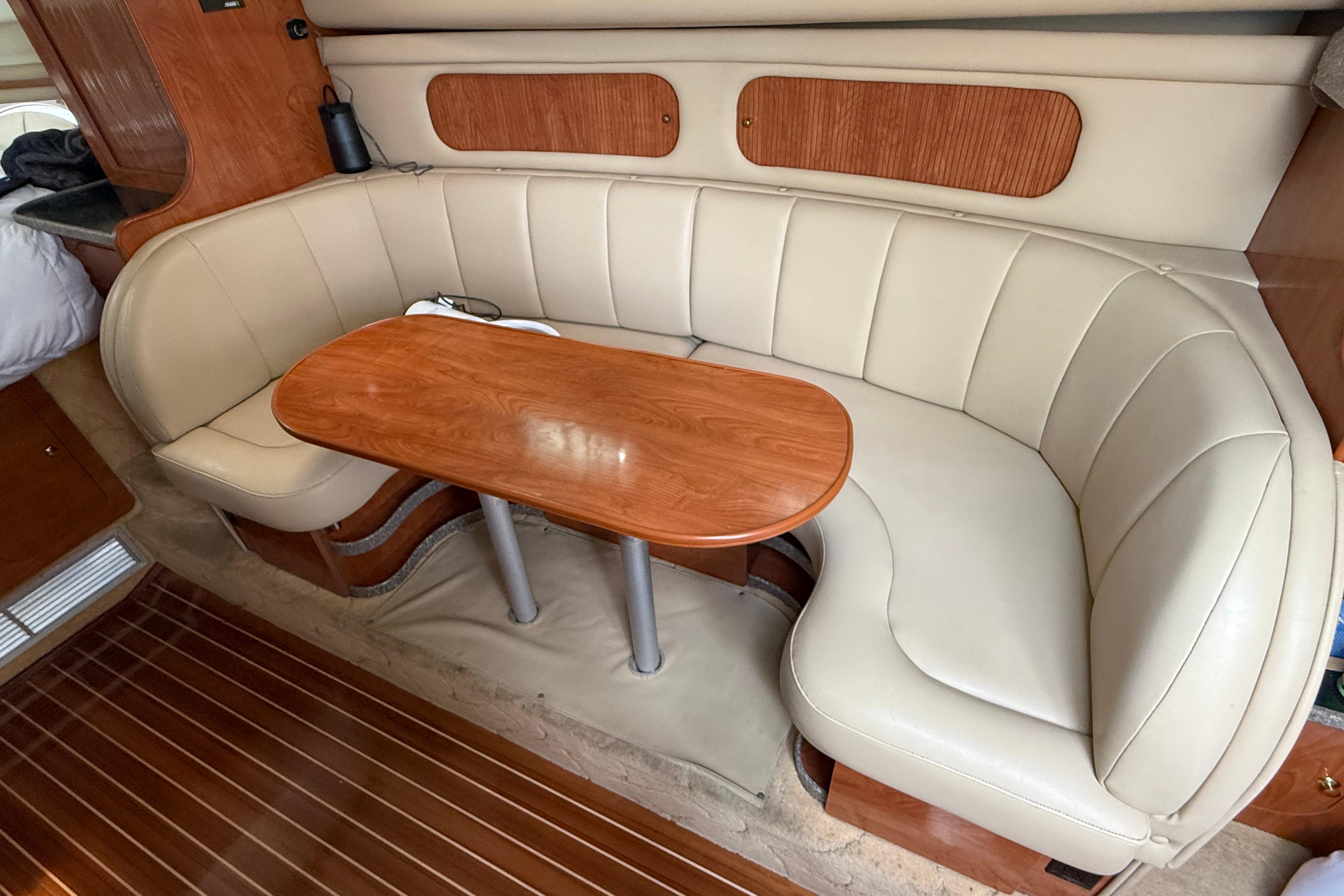 2004 Rinker 342 yacht interior with beige leather seating and wooden table.