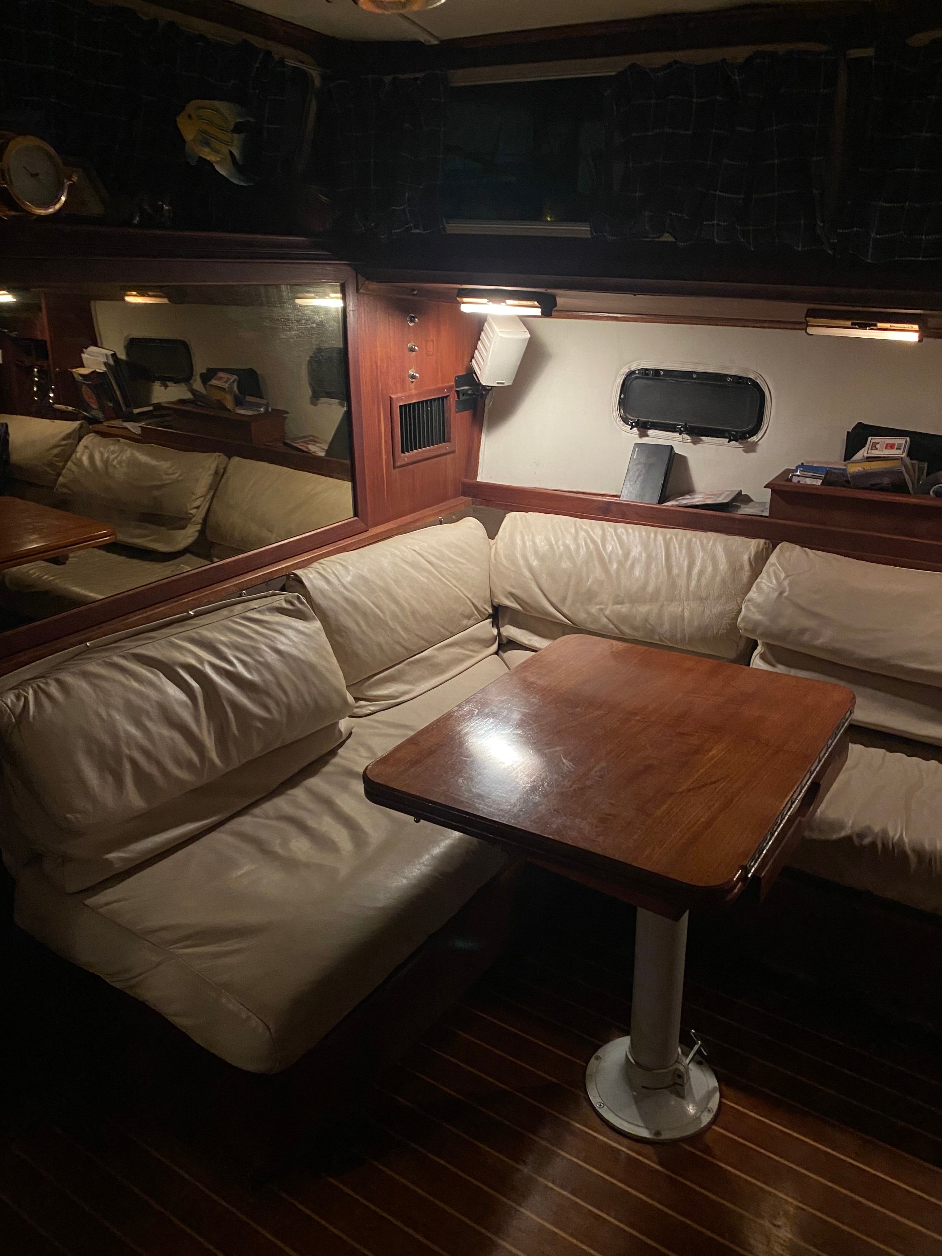 Interior of the 1983 Islander Freeport with a cozy seating area and wooden table.