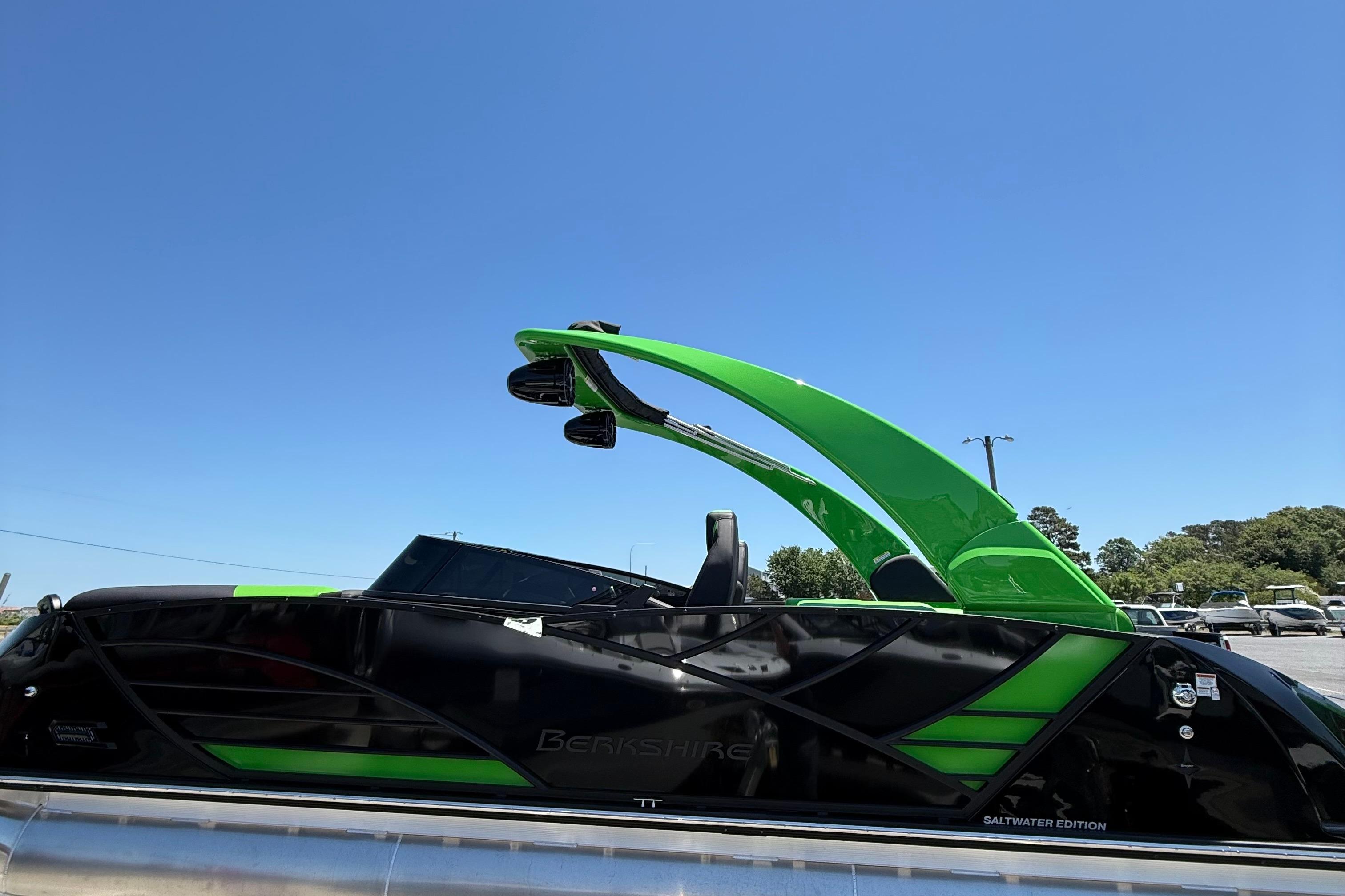 2026 Berkshire Sport SLX9 DC boat, black and green, under clear blue sky.