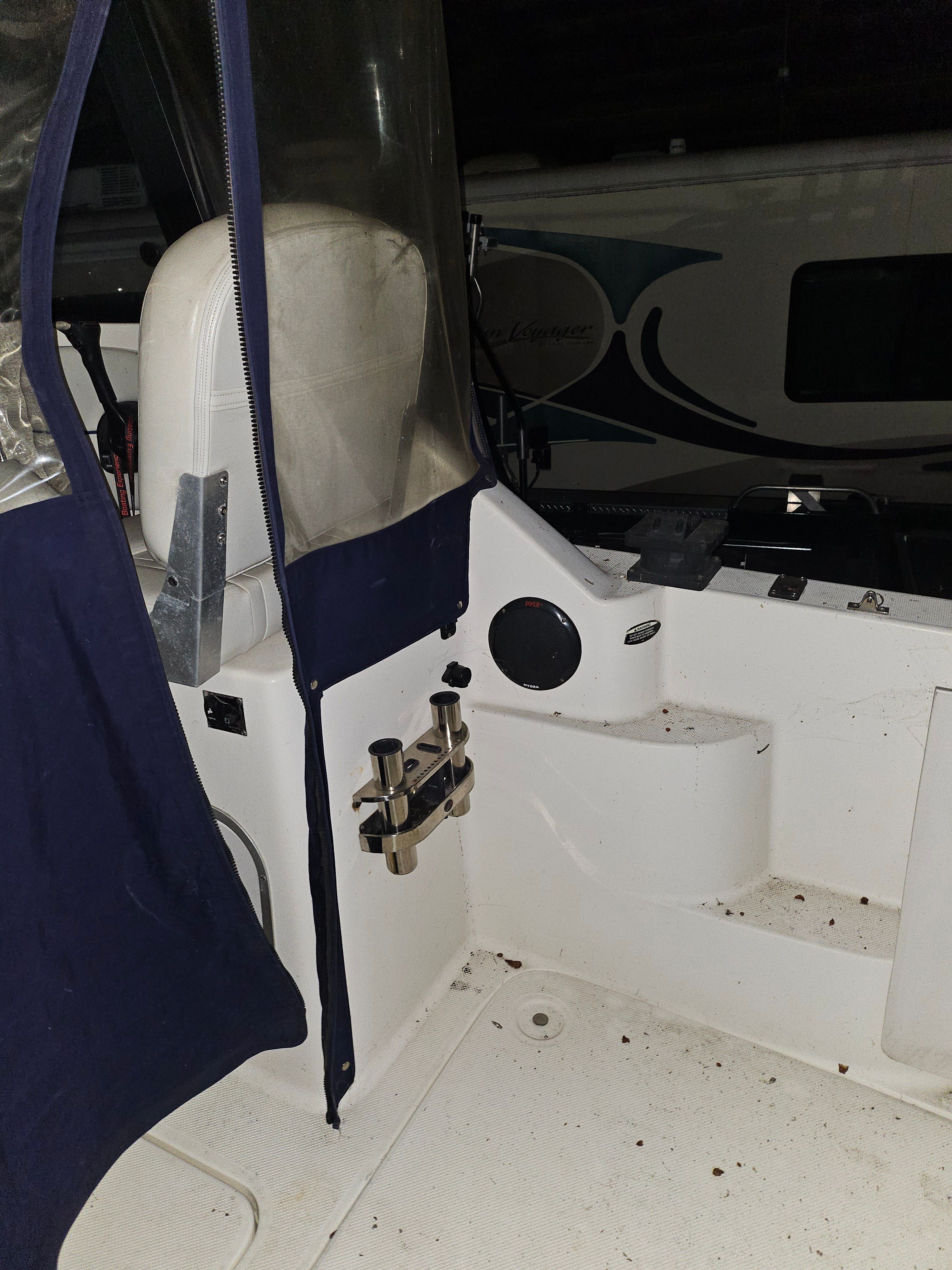 The image shows the cockpit of a 2005 Bayliner 242 Ceara boat with blue covers.