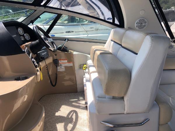 Interior of a 2008 Four Winns V338 with beige and white seating and a helm station.