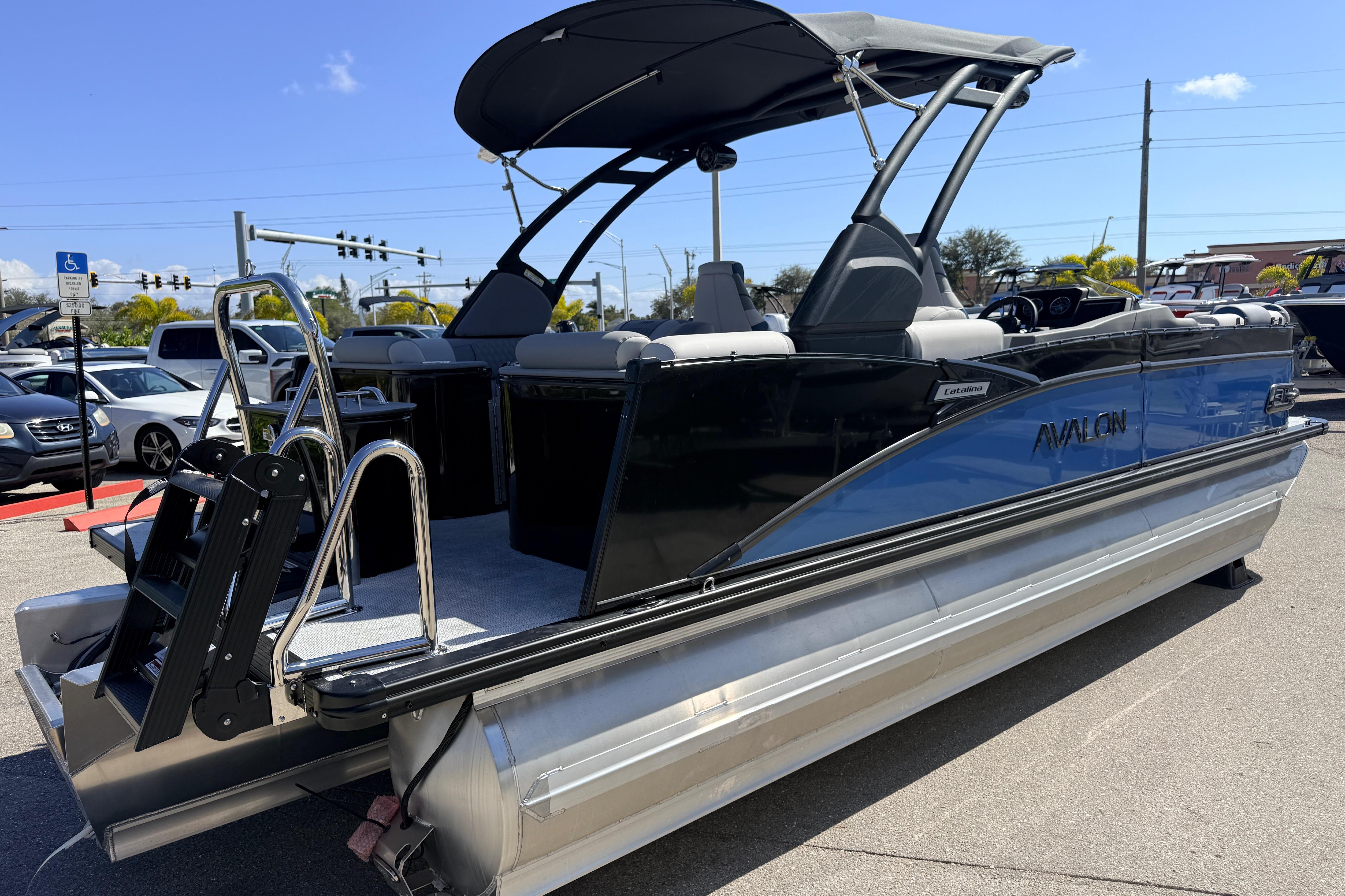 2026 Avalon 2385 Catalina Quad Lounger Tri Toon boat, sleek design, parked outdoors.