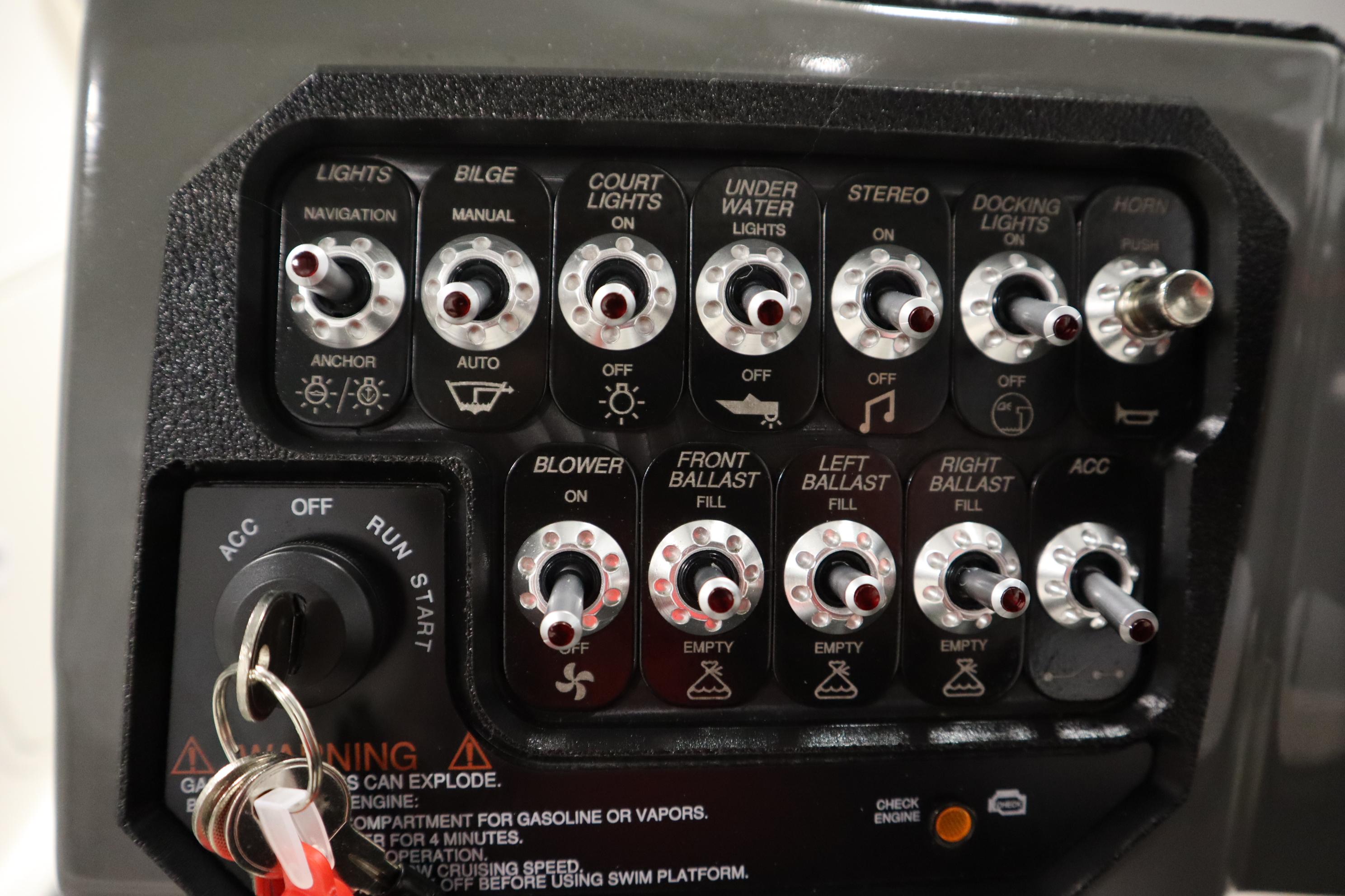 Control panel of 2023 Heyday WT Surf boat with various switches and key ignition.