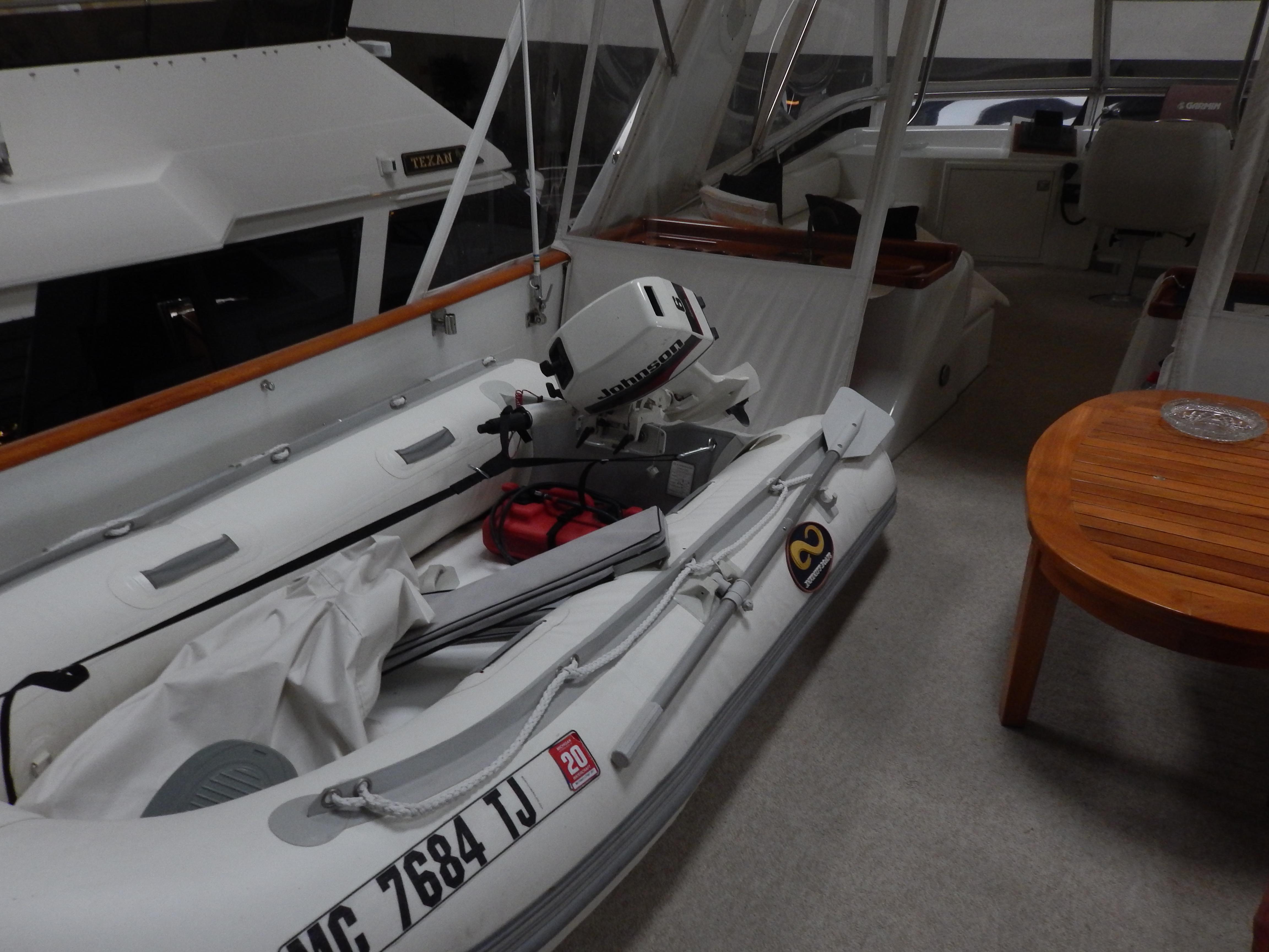 1974 Pacemaker Cockpit Motoryacht with inflatable boat and outboard motor on deck.