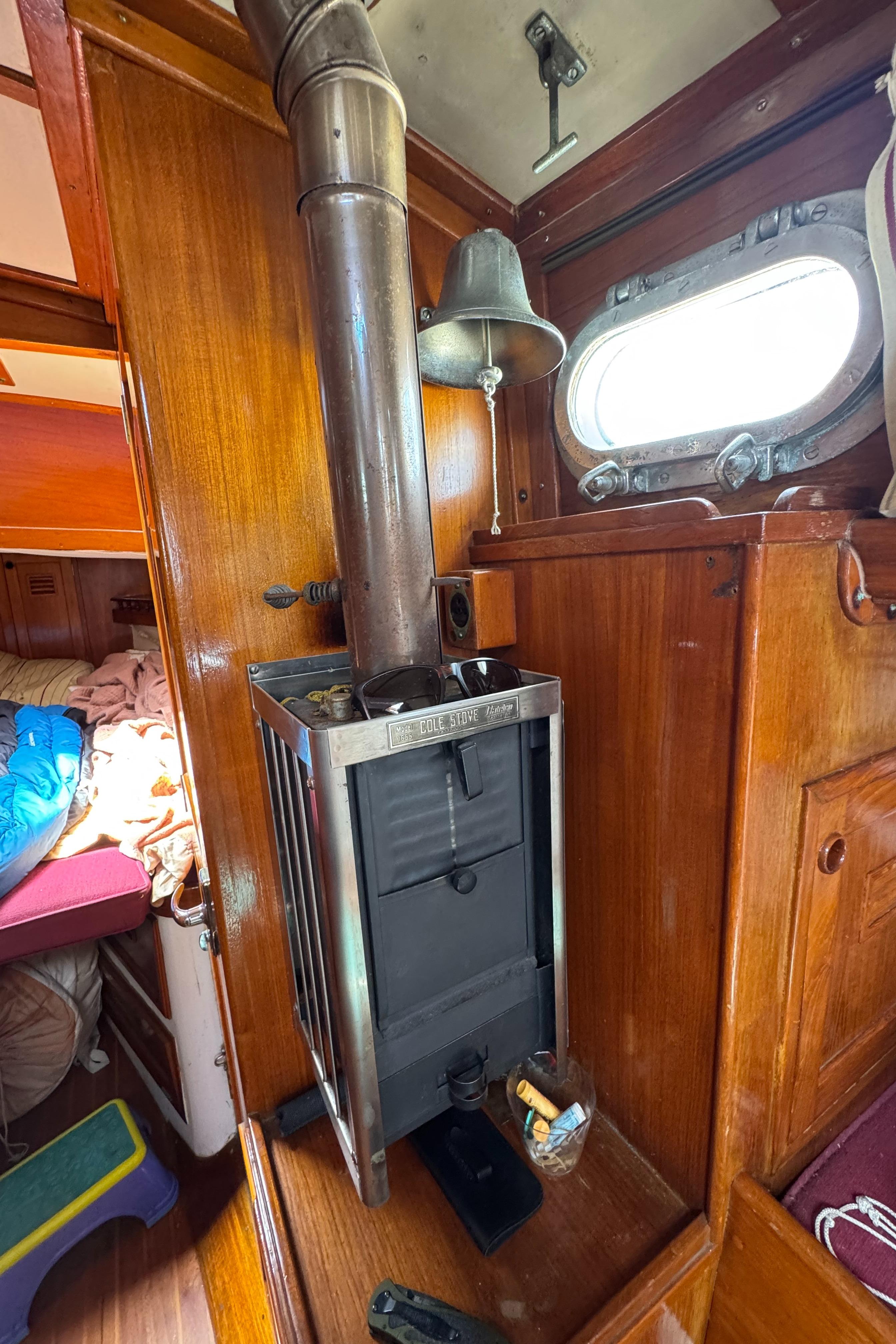 1979 Cheoy Lee Bill Luders Clipper Ketch interior with wood stove and porthole.