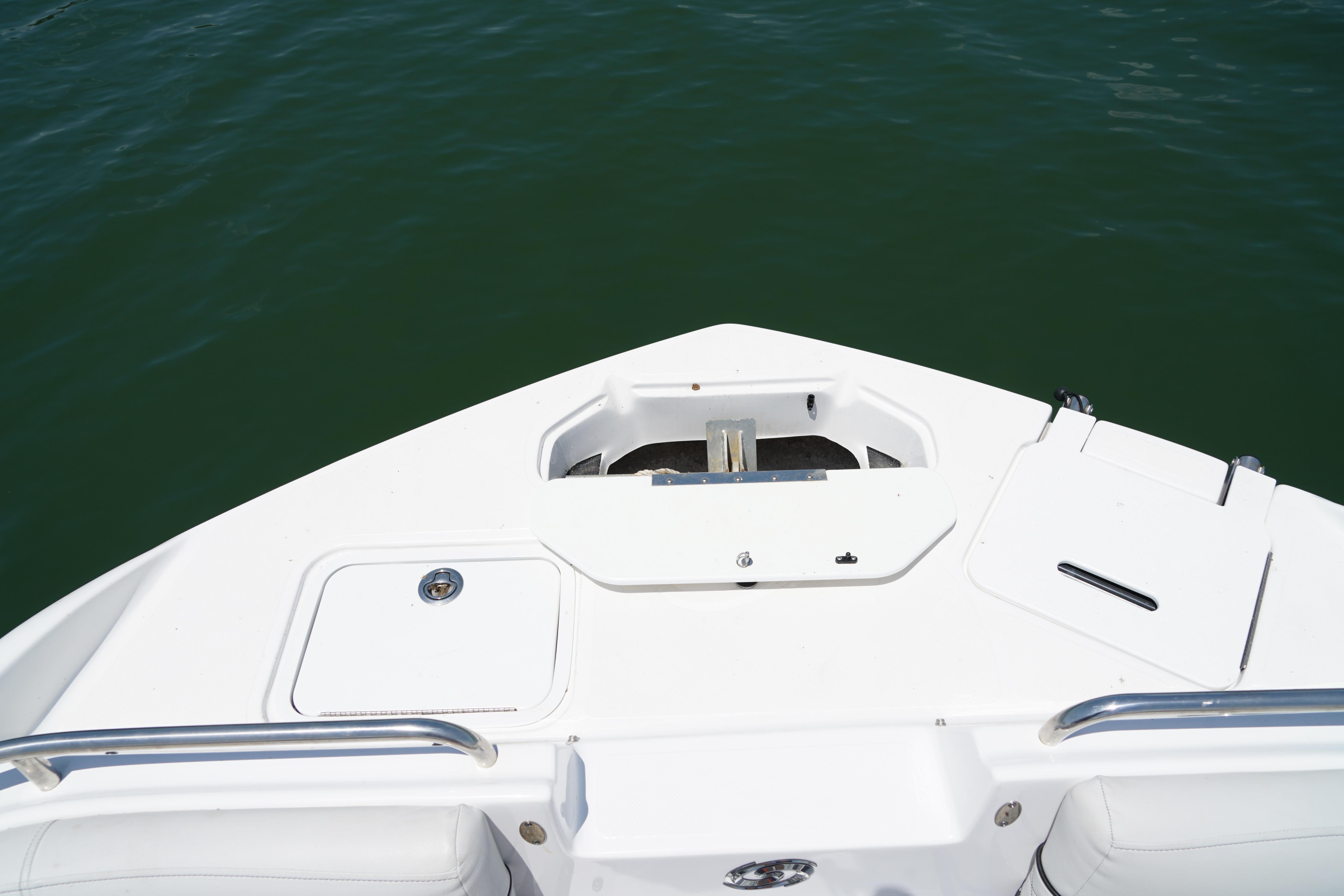 2020 Hurricane SunDeck 2486 OB boat bow with storage compartments on calm water.