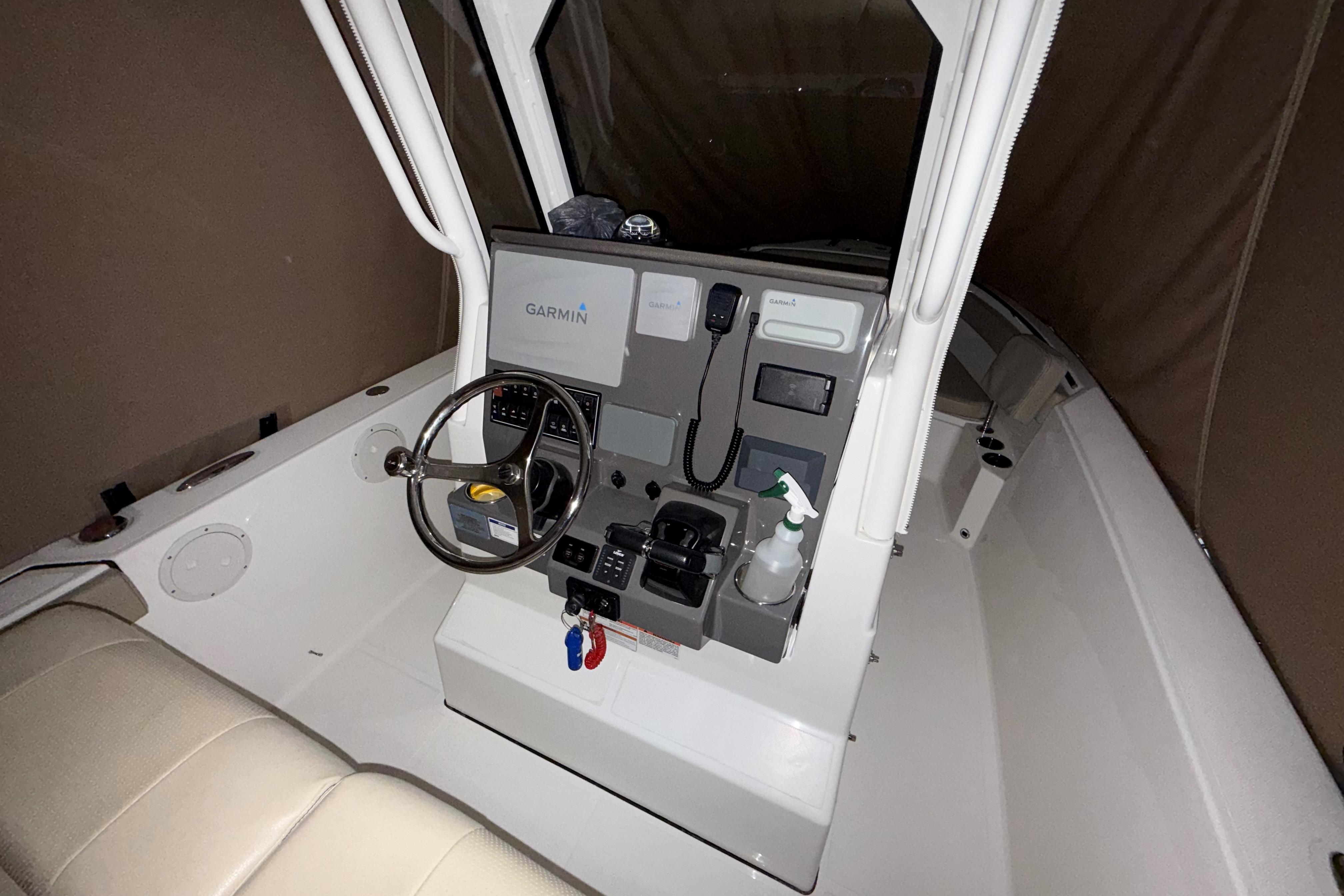 2021 Pursuit S 268 Sport boat cockpit with Garmin navigation system and steering wheel.