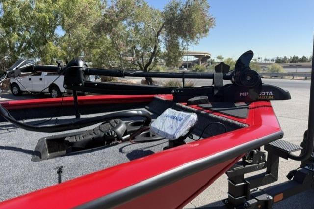 2026 Tracker Pro Team 190 boat with red exterior, parked outdoors.
