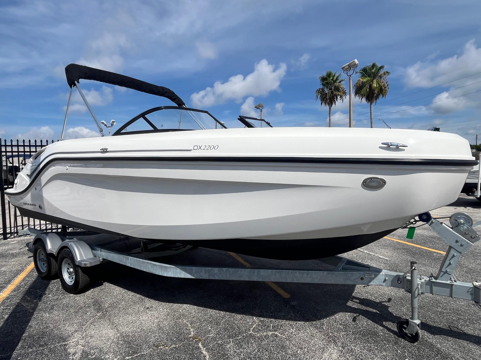 2022 Bayliner DX 2200 boat on trailer under blue sky.