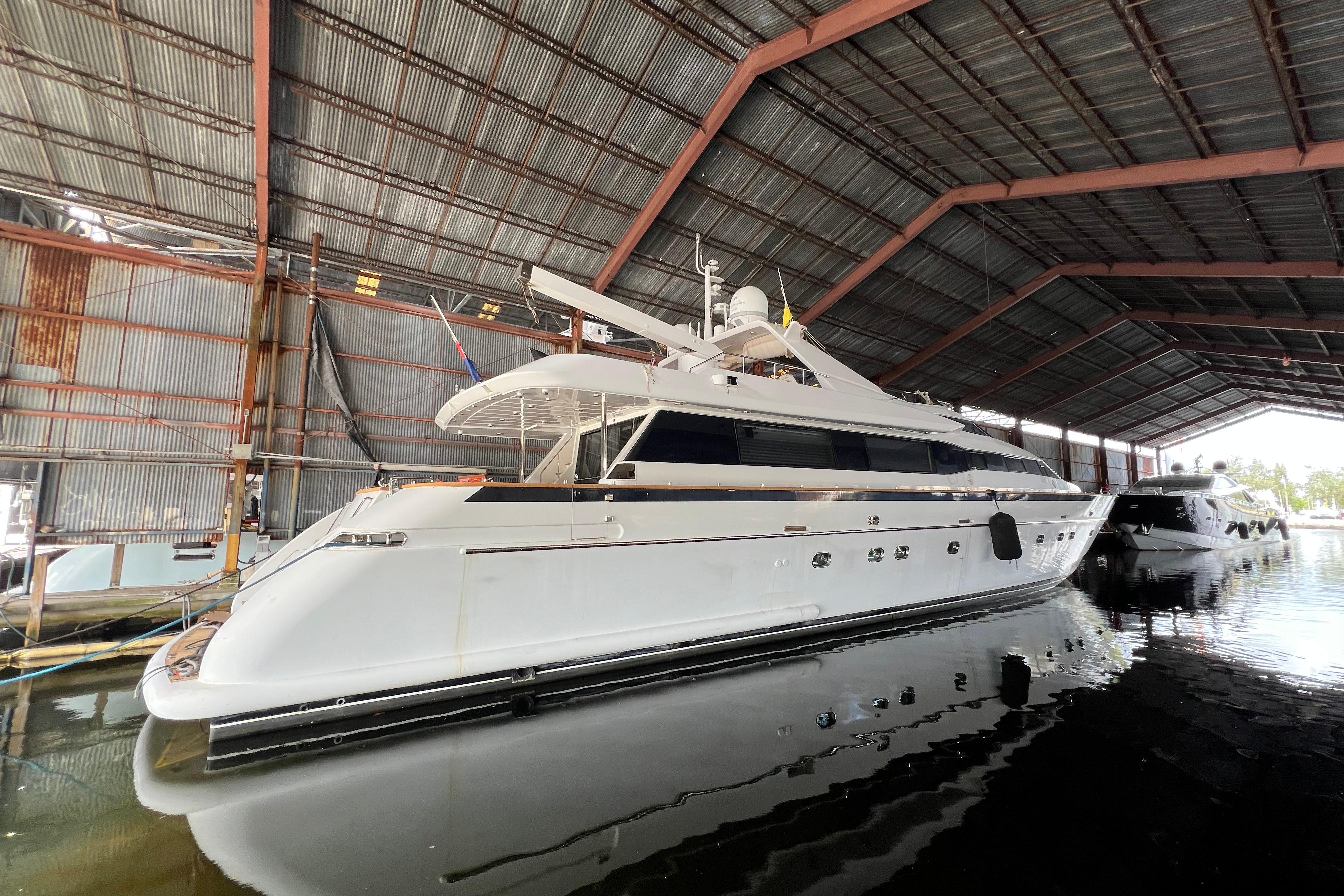 Luxury Falcon 106 yacht from 2001 docked in a covered marina.