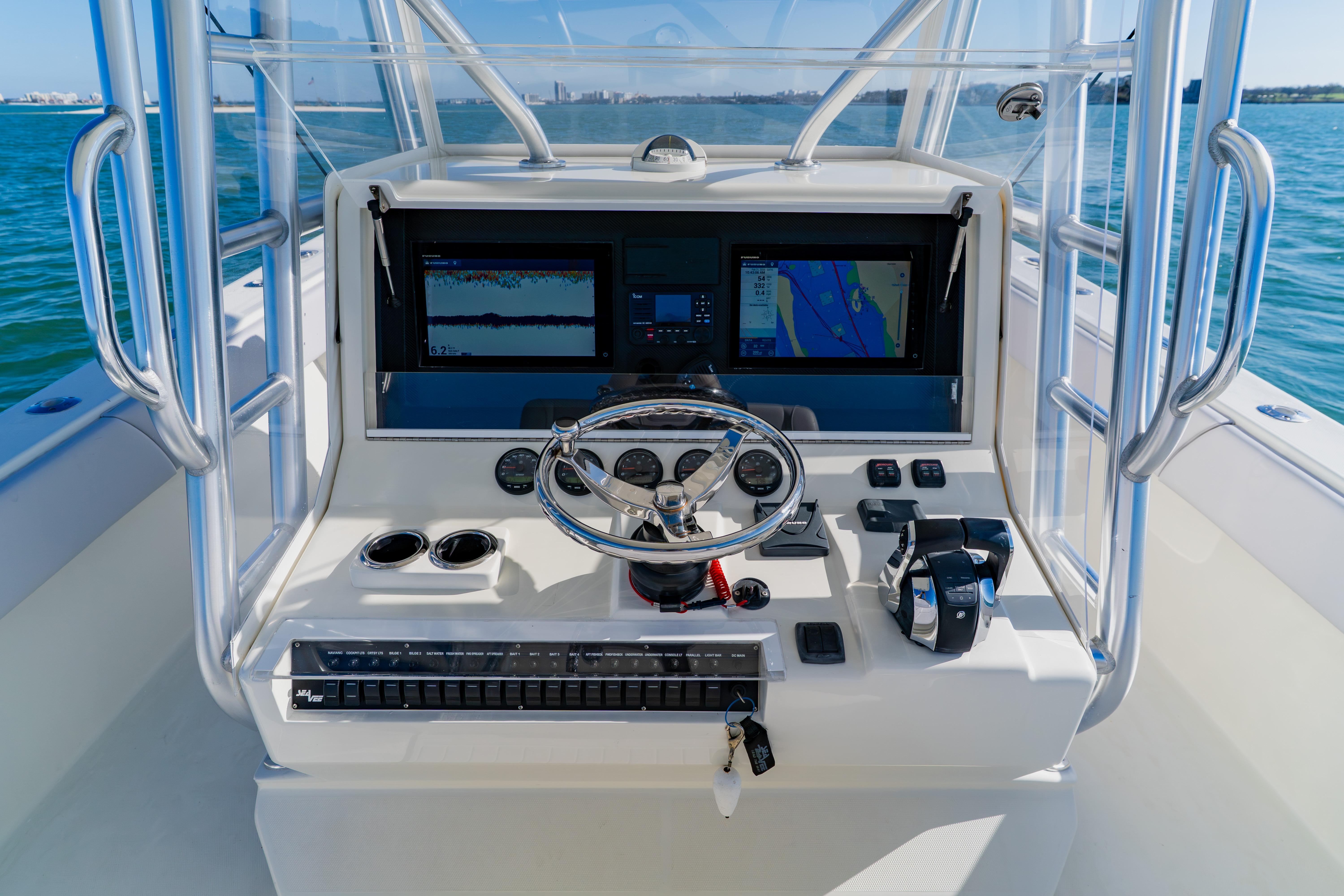 2012 SeaVee 390B boat dashboard with navigation screens and steering wheel on open water.